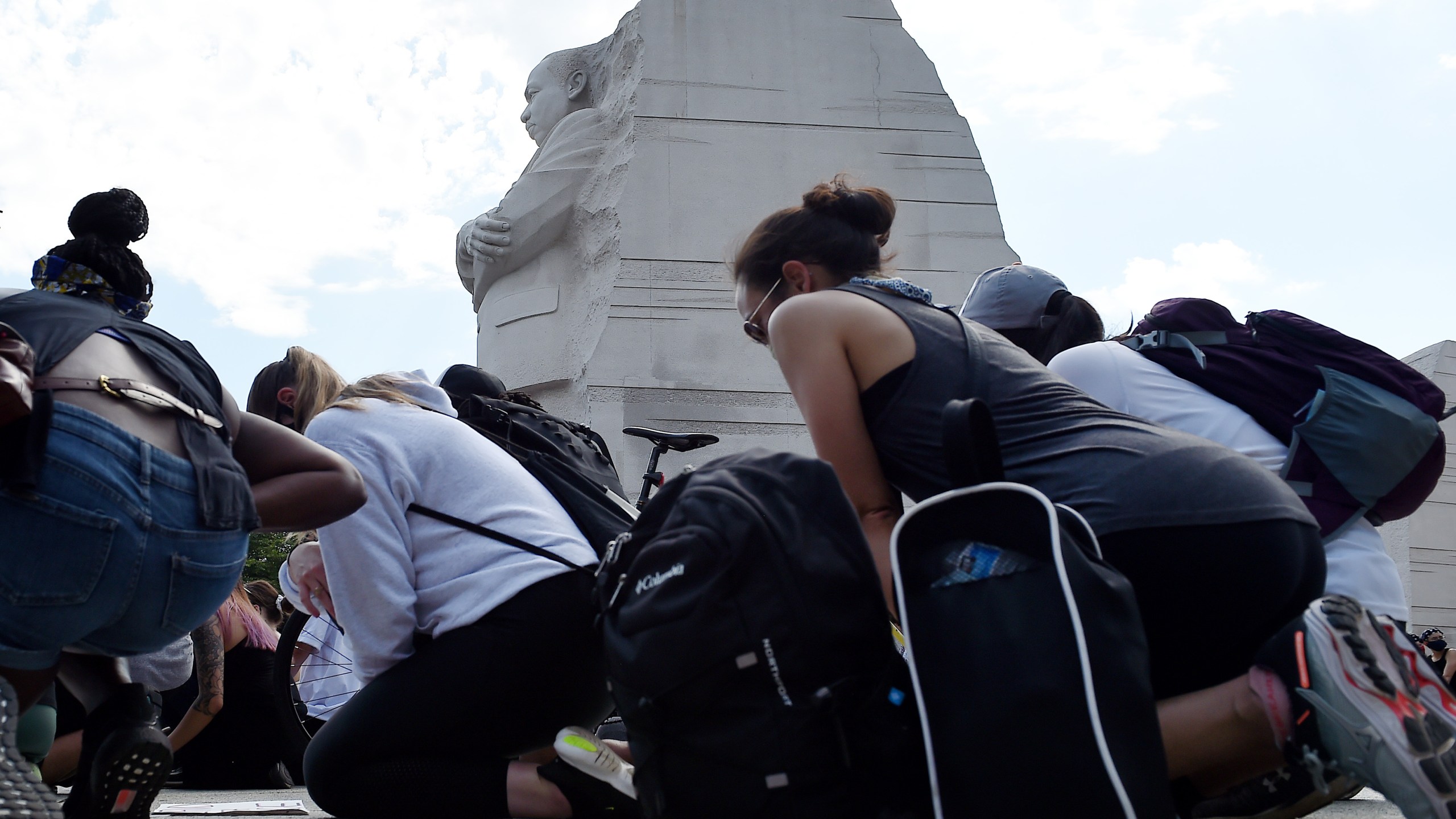 Demonstrators kneel down at The Martin Luther King Jr. Memorial in Washington, D.C., as they protest the death of George Floyd on June 4, 2020. (OLIVIER DOULIERY/AFP via Getty Images)