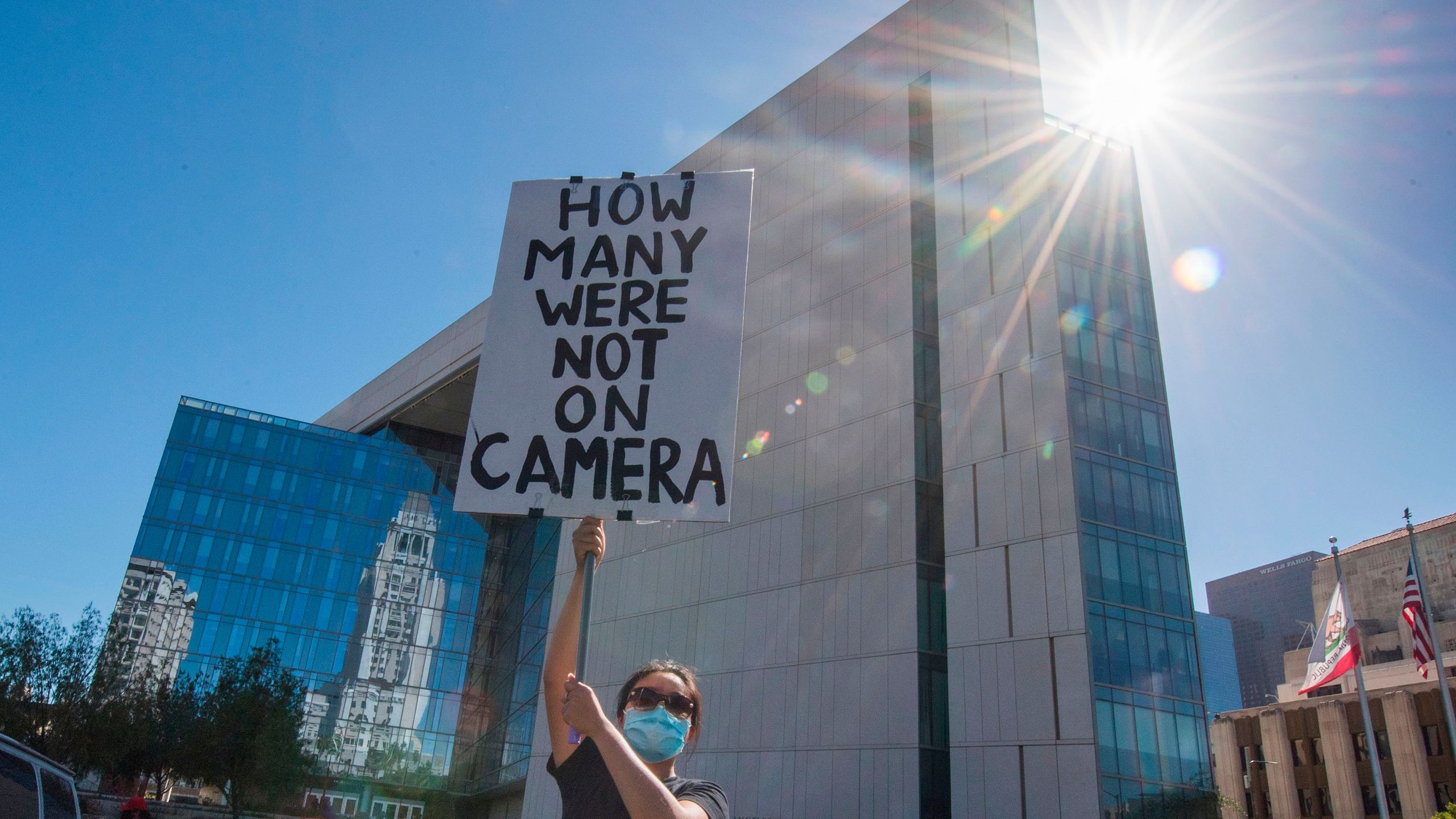 A supporter of Black Lives Matter holds a protest sign outside the Los Angeles Police Department headquarters on June 7, 2020. (MARK RALSTON/AFP via Getty Images)