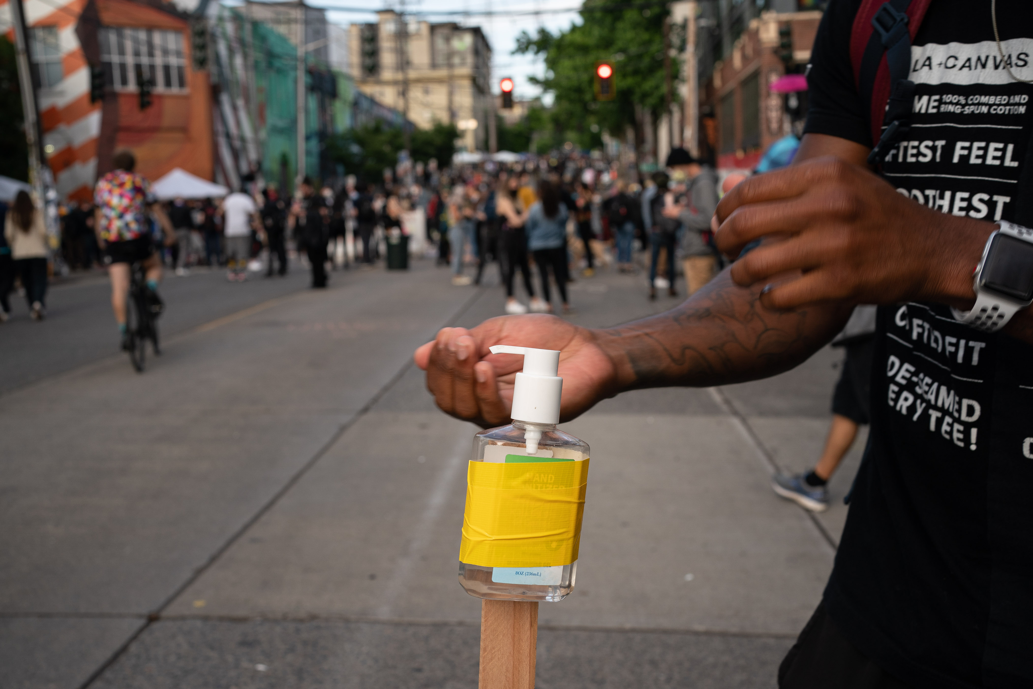 A person uses free hand sanitizer in Seattle’s "Capitol Hill Autonomous Zone" on June 10, 2020. (David Ryder / Getty Images)