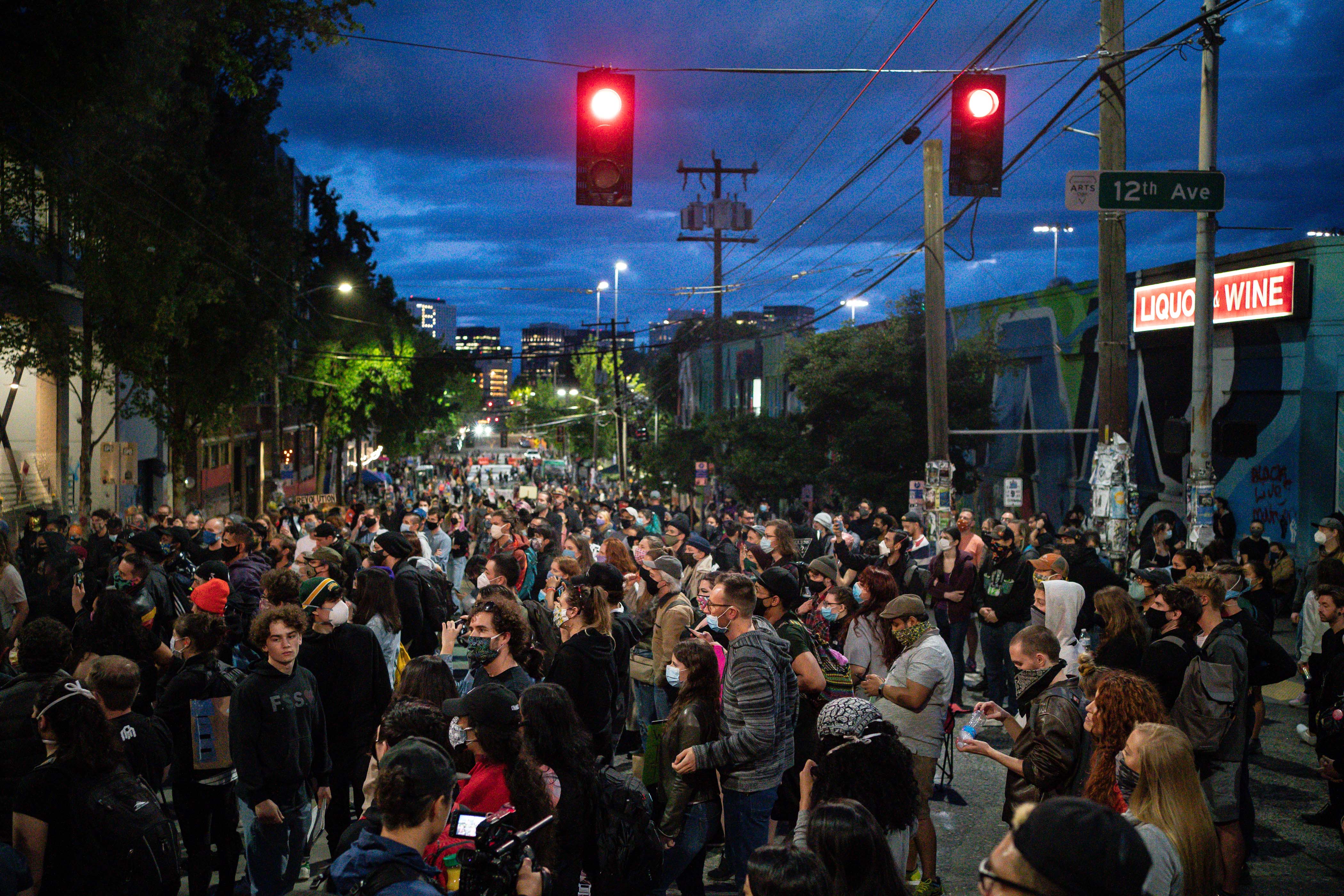 People listen as a band plays a free show in front of the Seattle Police Department's East Precinct in the "Capitol Hill Autonomous Zone" on June 10, 2020. (David Ryder / Getty Images)