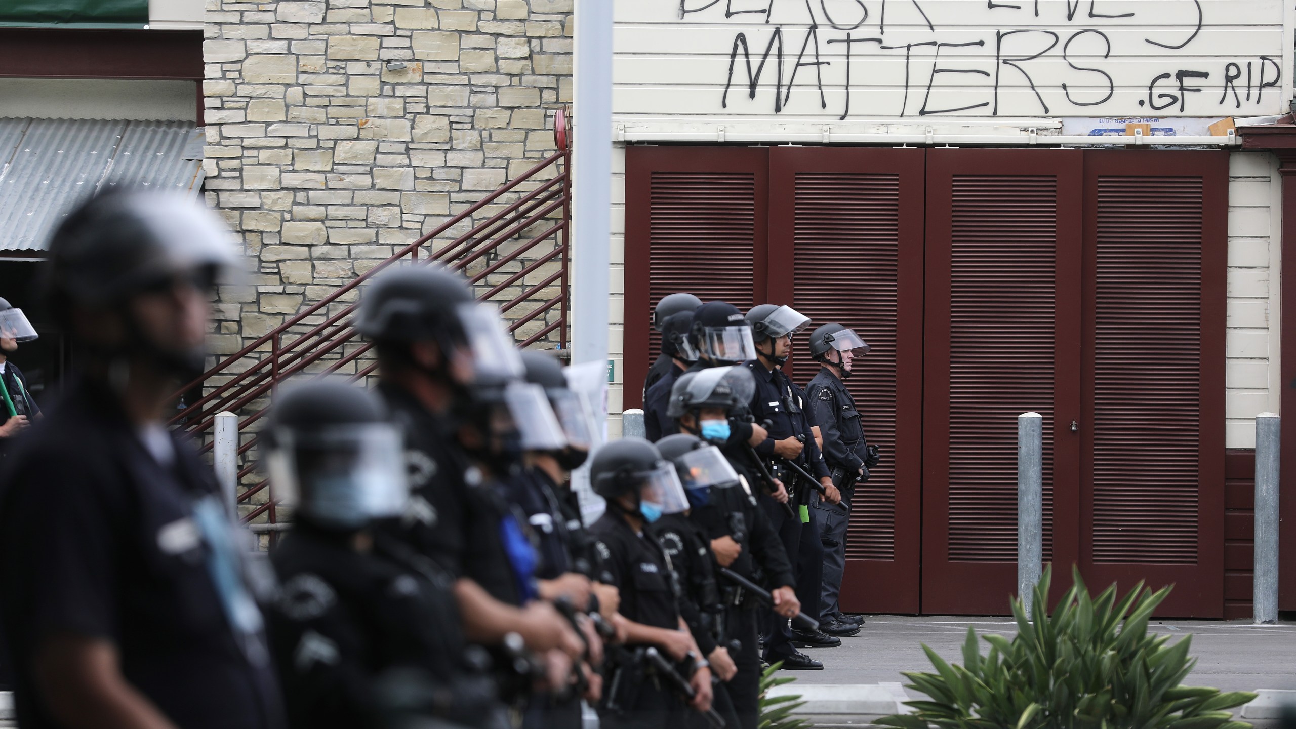 LAPD officers keep watch beneath graffiti reading 'Black Lives Matters' during demonstrations following the death of George Floyd on May 30, 2020. (Mario Tama/Getty Images)