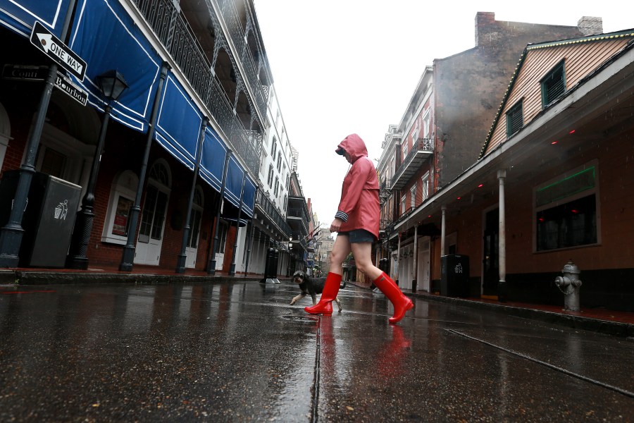 A woman walks her dog through the French Quarter as Tropical Storm Cristobal nears the coast on June 7, 2020, in New Orleans, Louisiana. (Sean Gardner/Getty Images)