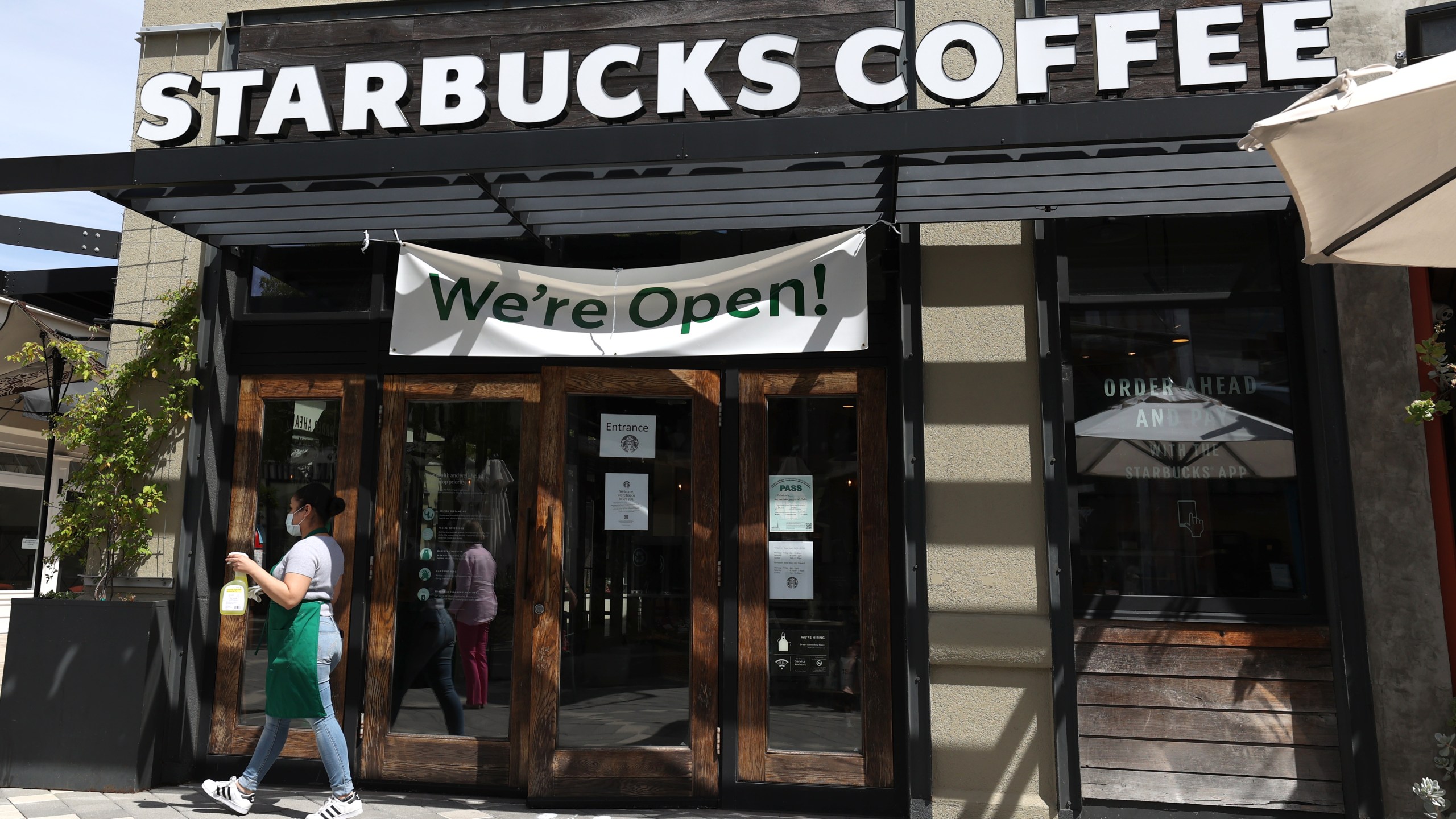 A Starbucks worker prepares to clean the door at a Starbucks Coffee store on June 10, 2020 in Corte Madera. (Justin Sullivan/Getty Images)