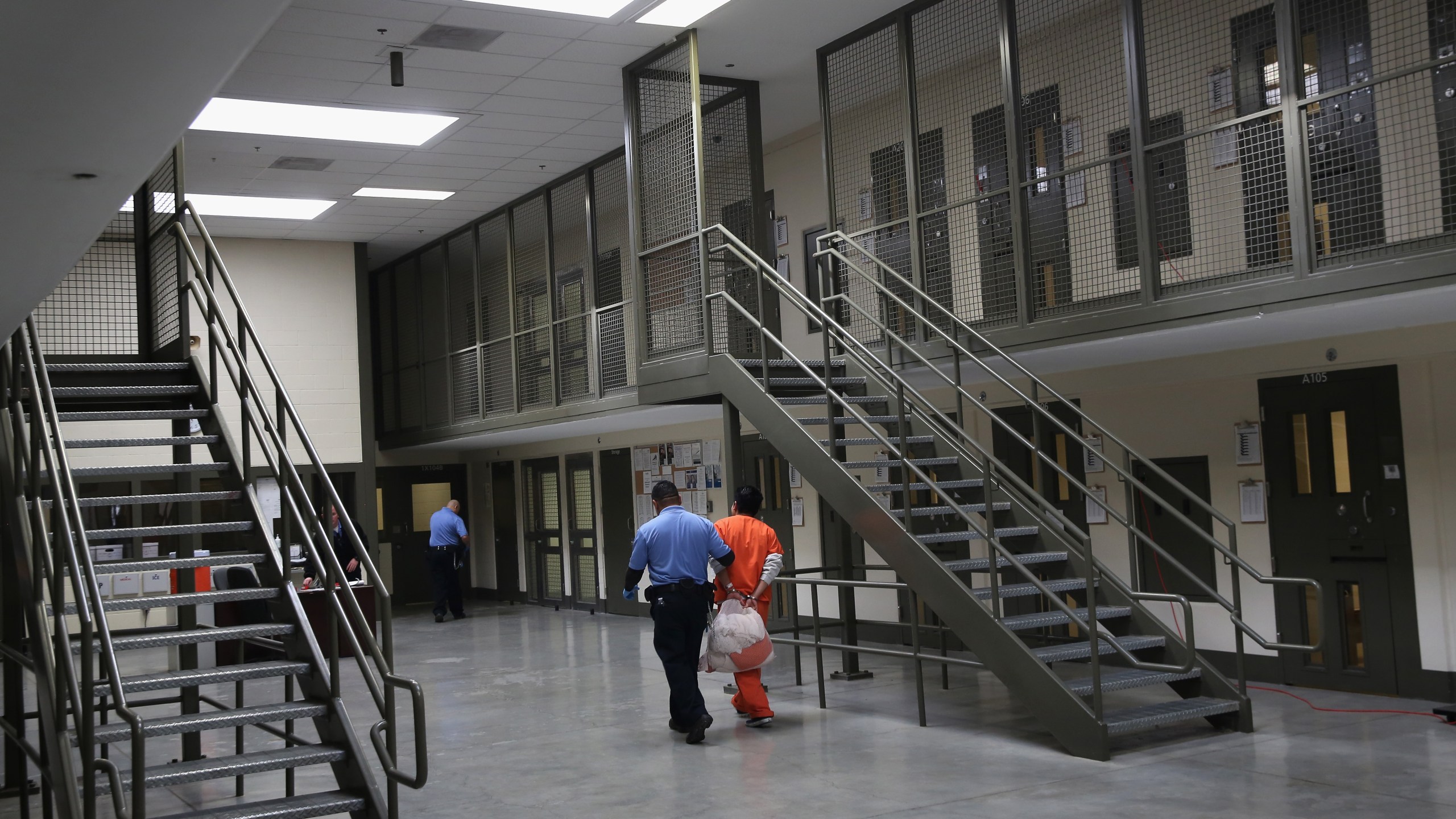 A guard escorts an immigrant detainee from his "segregation cell" back into the general population at the Adelanto Detention Facility on Nov. 15, 2013, in Adelanto. (John Moore/Getty Images)