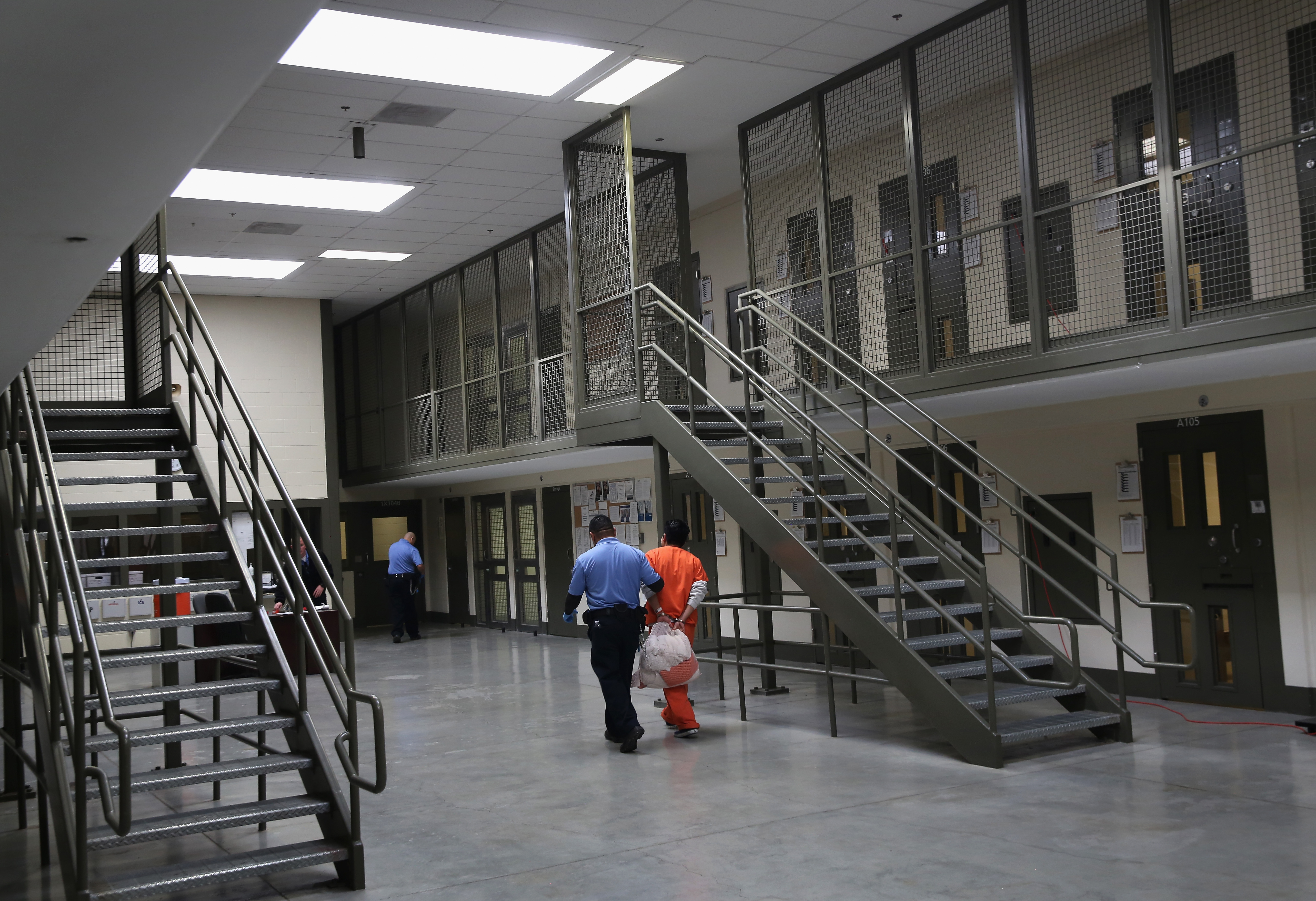 A guard escorts an immigrant detainee from his "segregation cell" back into the general population at the Adelanto Detention Facility on Nov. 15, 2013, in Adelanto. (John Moore/Getty Images)