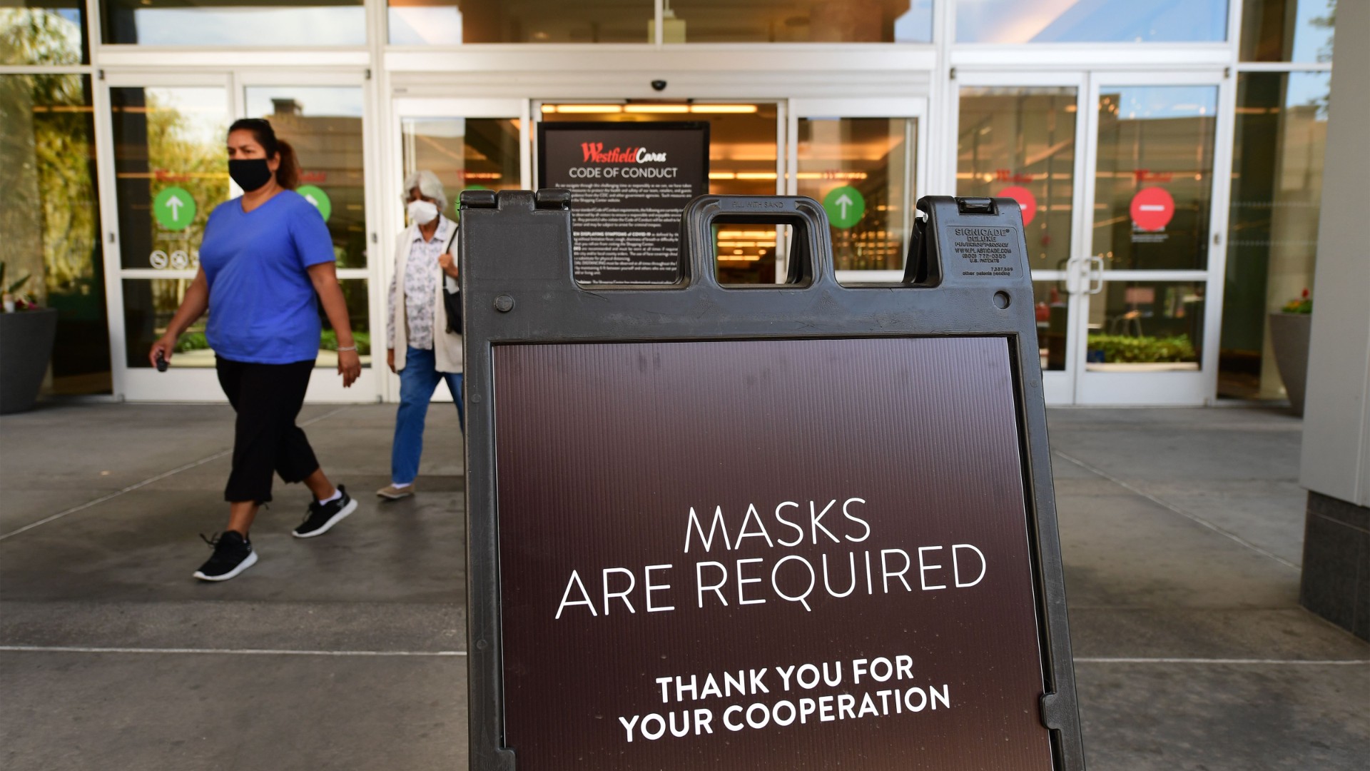 Women wearing facemasks exit a shopping mall where a sign is posted at an entrance reminding people of the mask requirement Westfield Santa Anita shopping mall on June 12, 2020 in Arcadia, California, as Phase 3 in Los Angeles County's battle with the coronavirus pandemic is underway with businesses reopening. (Frederic J. Brown/AFP/Getty Images)