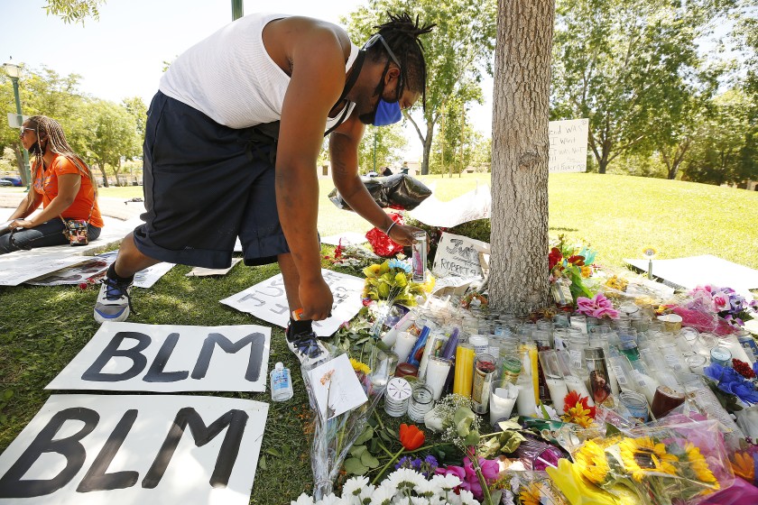 Deonte Kemp lights candles at a memorial for Robert Fuller in Poncitlan Square next to Palmdale City Hall in June 2020. (Al Seib / Los Angeles Times)