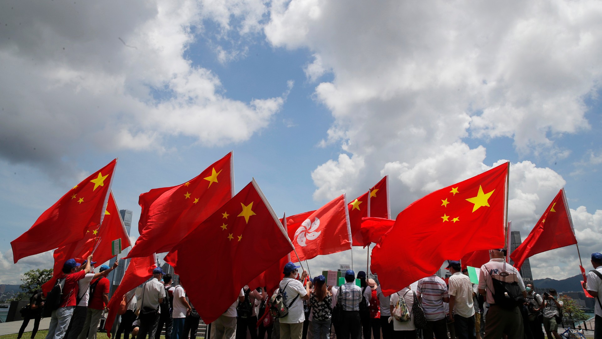 Pro-China supporters hold Chinese and Hong Kong national flags during a rally to celebrate the approval of a national security law for Hong Kong, in Hong Kong, Tuesday, June 30, 2020. (AP Photo/Kin Cheung)