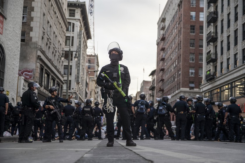 LAPD officer Decote watches for people tossing debris from tall buildings as dozens of protesters are arrested for curfew violations on Broadway on June 2, 2020.(Robert Gauthier/Los Angeles Times)