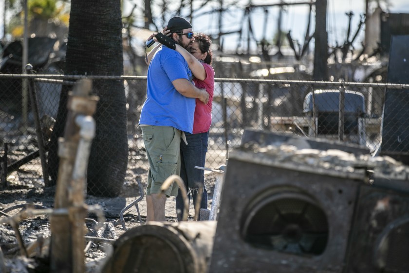 Guadalupe and Daniel Altamirano comfort each other as they survey the ashes of their cousin’s home in Niland on June 29, 2020. (Robert Gauthier / Los Angeles Times)