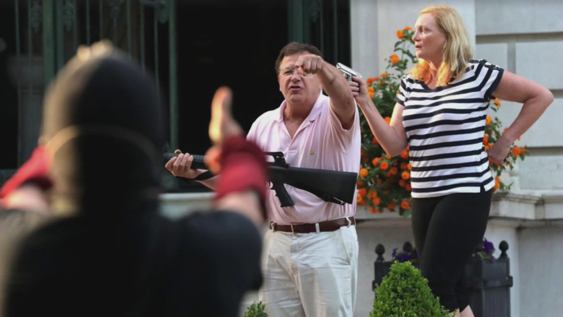 A couple draws their firearms on protestors as they enter their neighborhood during a protest against Mayor Lyda Krewson in St. Louis, Missouri, on June 28, 2020. (St. Louis Post-Dispatch/Laurie Skrivan via AP)