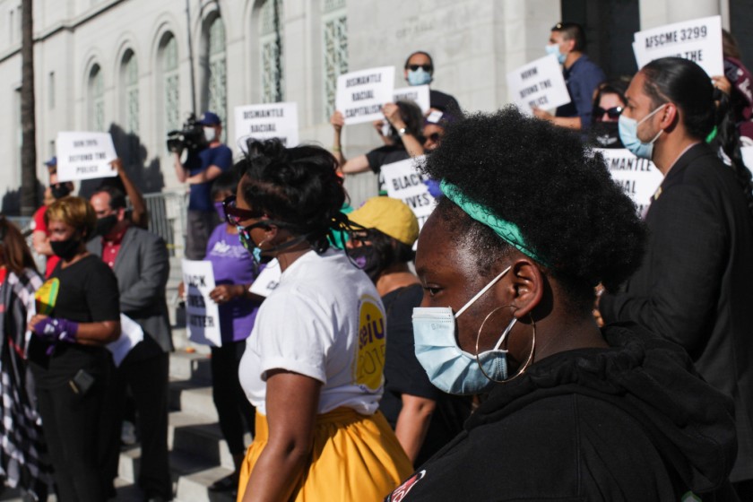 Sarah Djato, right, listens to speakers during a news conference calling for the removal of police from the Los Angeles school system on June 8, 2020 in Los Angeles. (Gabriella Angotti-Jones / Los Angeles Times)