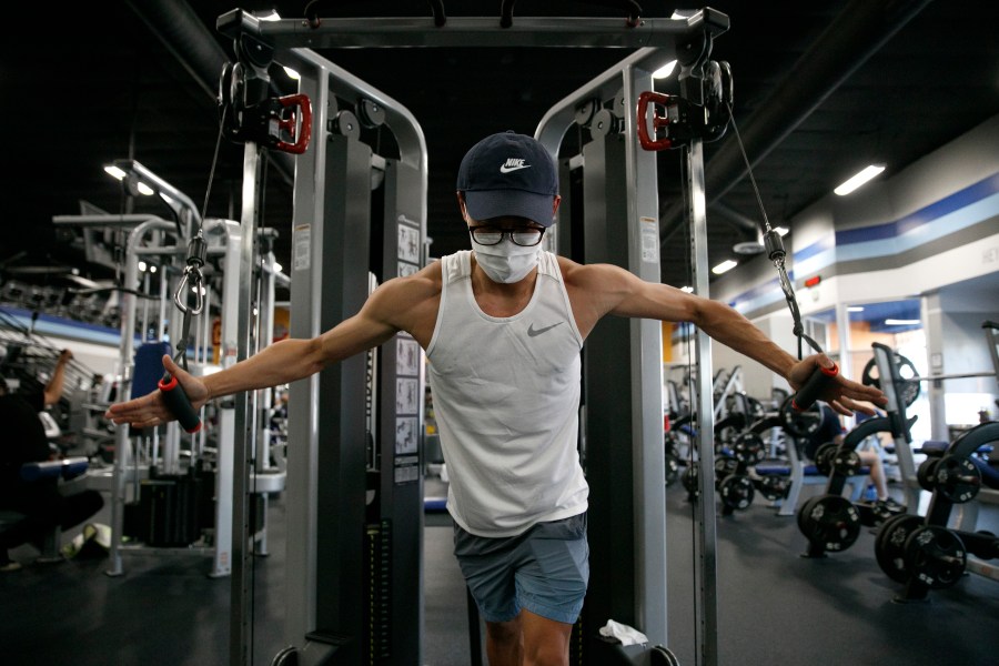 A man wears a mask while working out at a gym in Los Angeles, on June 26, 2020. (AP Photo/Jae C. Hong)