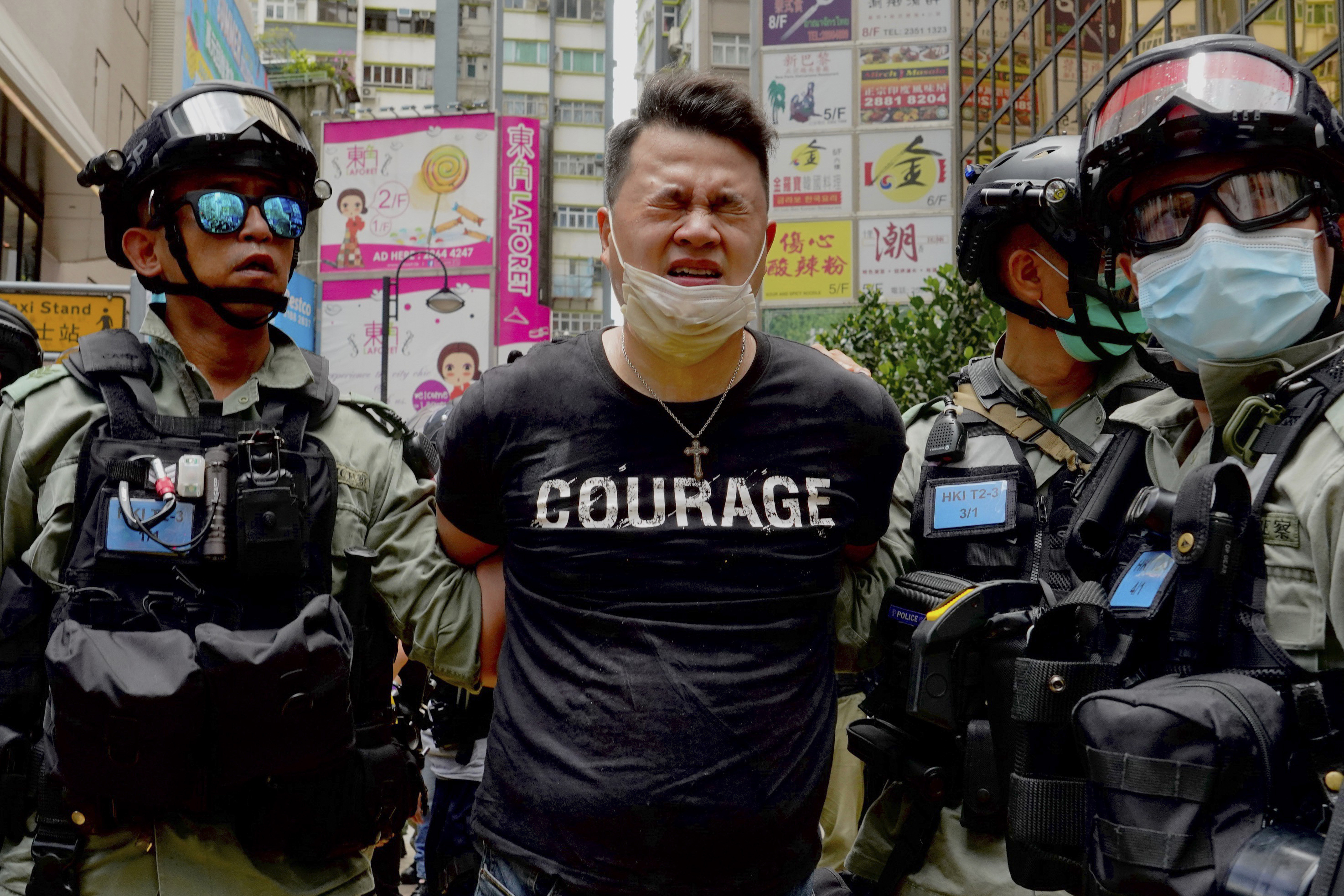 Police detain a protester after spraying pepper spray during a protest in Causeway Bay before the annual handover march in Hong Kong, Wednesday, July. 1, 2020. (AP Photo/Vincent Yu)