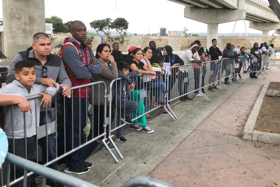 Asylum seekers in Tijuana, Mexico, listen to names being called from a waiting list to claim asylum at a border crossing in San Diego on Sept. 26, 2019. (AP Photo/Elliot Spagat,File)