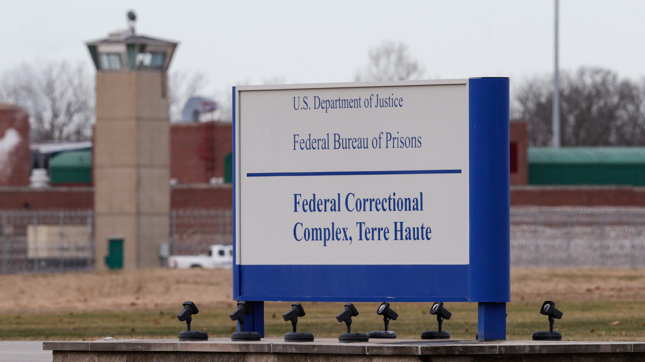 The guard tower flanks the sign at the entrance to the U.S. Penitentiary in Terre Haute, Indiana, on Dec. 10, 2019. (Michael Conroy / Associated Press)