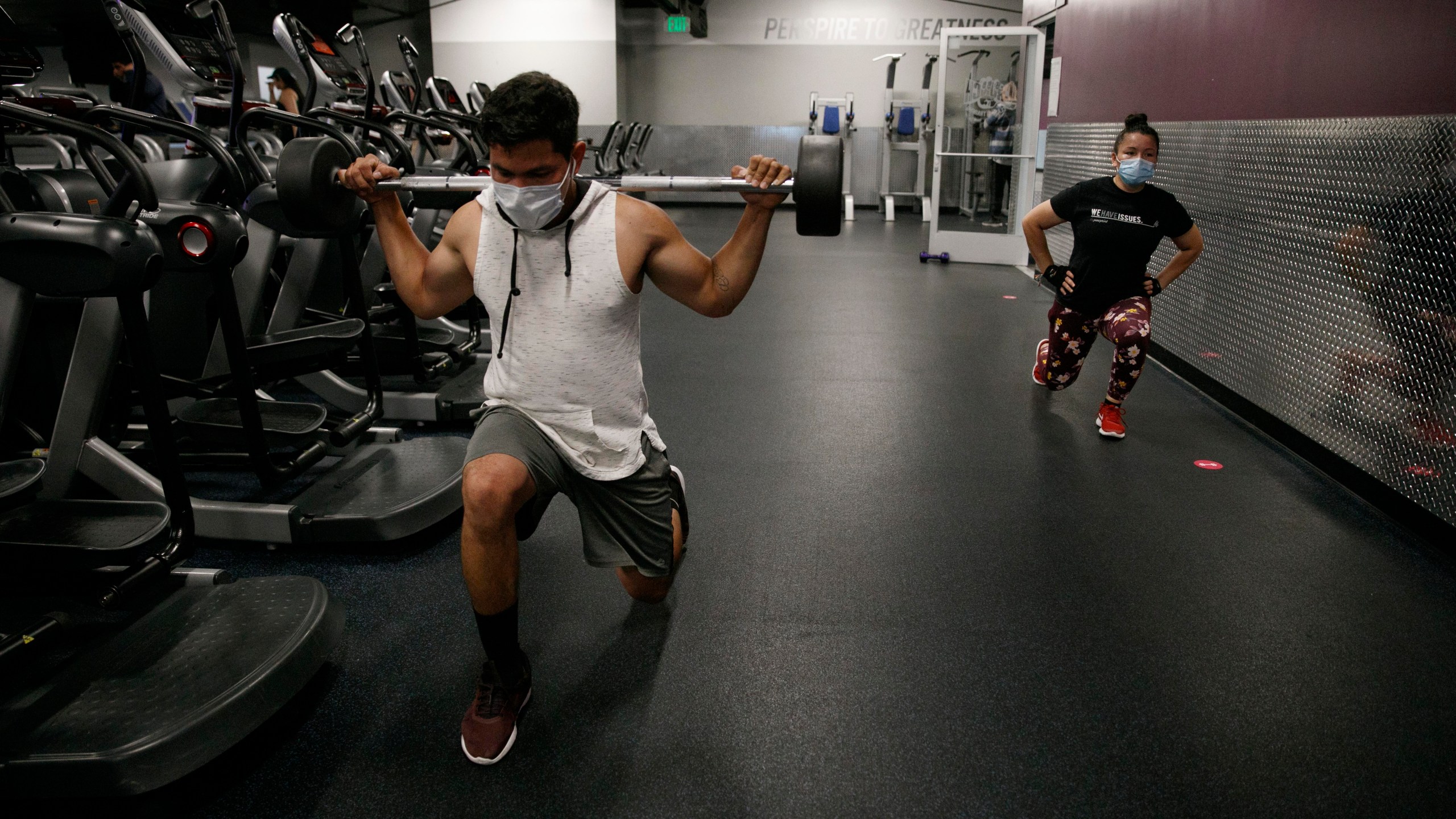 people wear masks while exercising at a gym in Los Angeles on June 26, 2020. (AP Photo/Jae C. Hong)