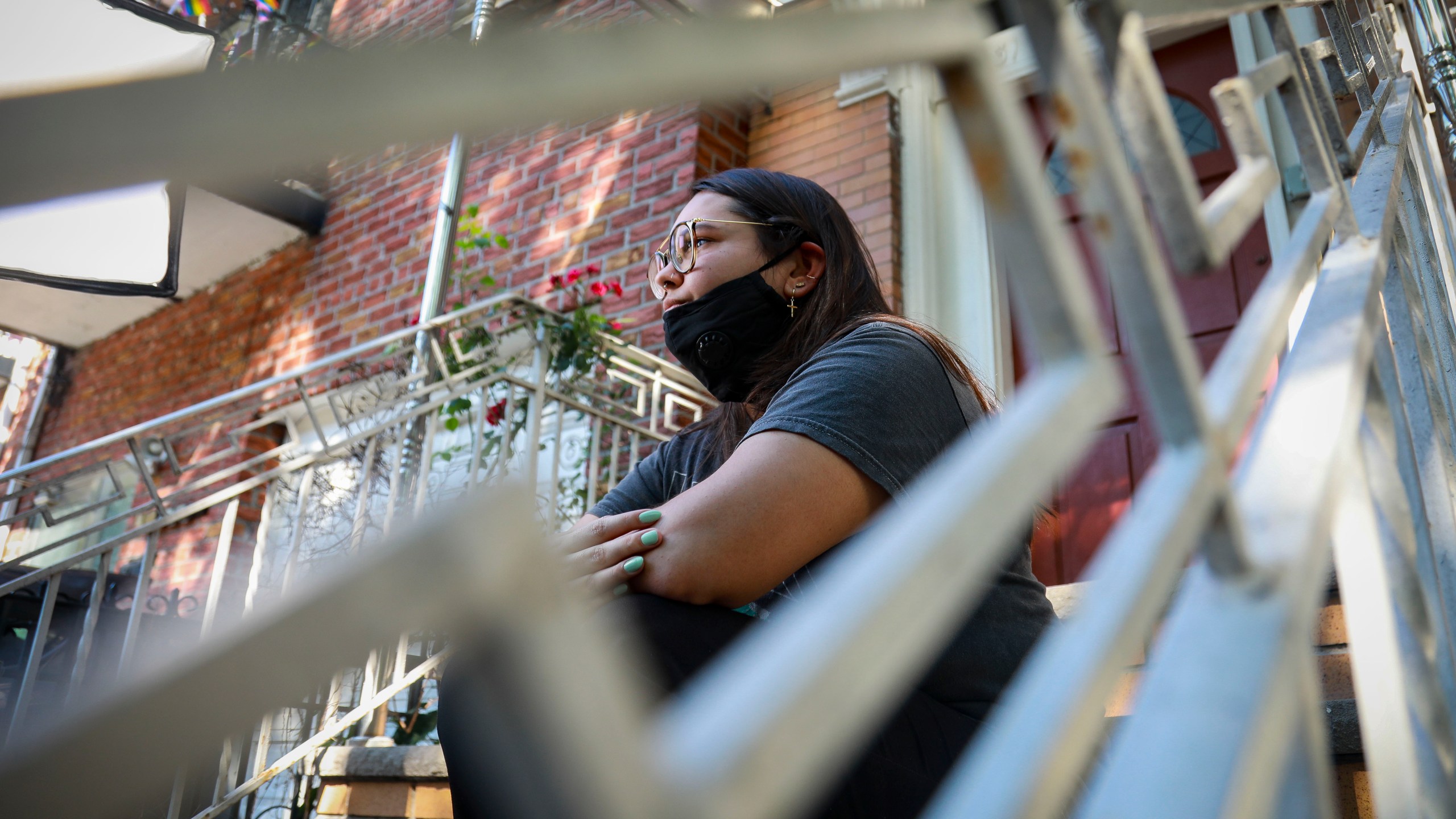 Natalia Afonso, 27, an international student from Brazil at Brooklyn College, sits on a stoop outside her home in New York during an interview on July 9, 2020. (Bebeto Matthews / Associated Press)