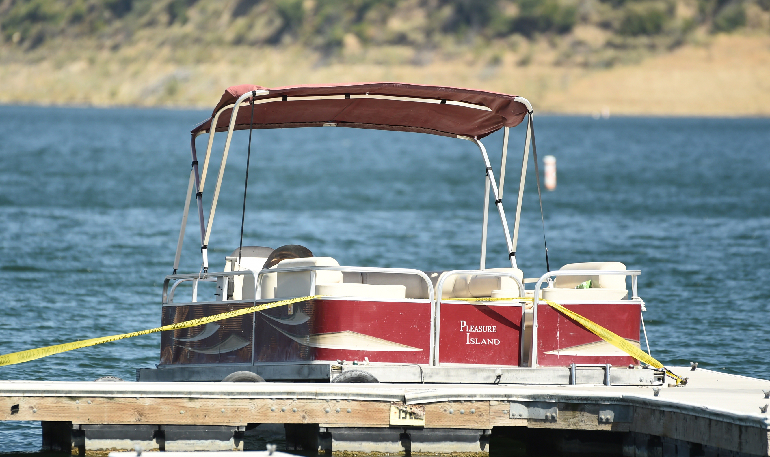 A boat covered in caution tape rented by "Glee" actress Naya Rivera sits at a dock while members of Ventura County Sheriff's Office Underwater Search and Rescue Team search for the actress on Thursday, July 9, 2020, at Lake Piru in Los Padres National Forest, northwest of Los Angeles. (AP Photo/Chris Pizzello)