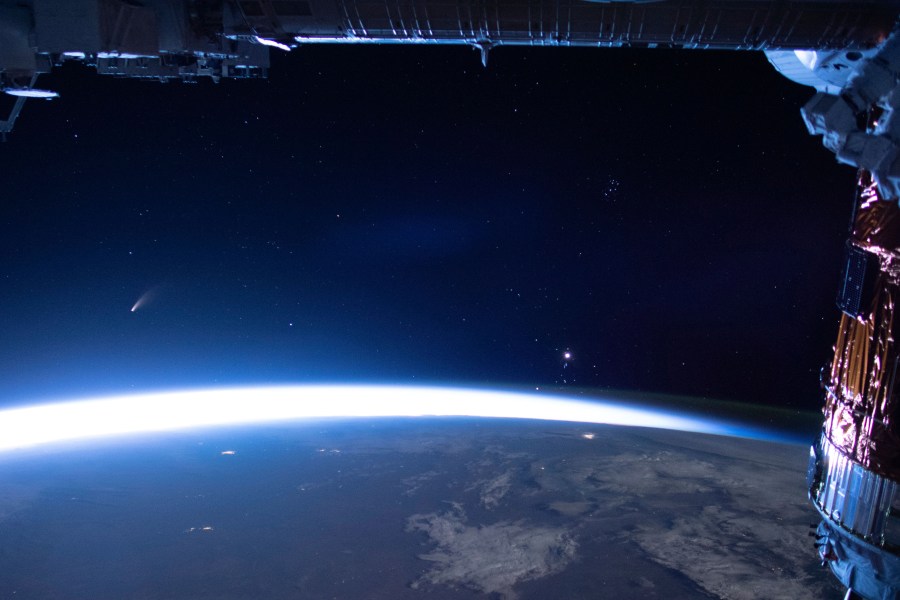 In this image released by NASA, Comet Neowise, left, is seen in the eastern horizon above Earth in this image taken from the International Space Station on Sunday, July 5, 2020. (NASA via AP)