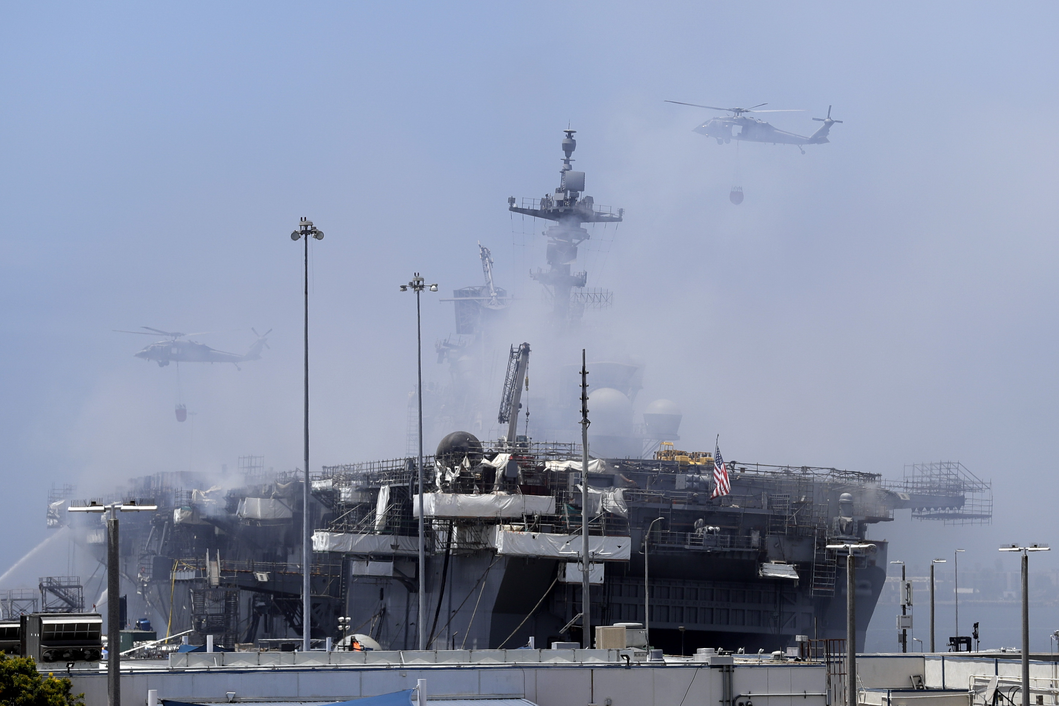 Helicopters approach the USS Bonhomme Richard as crews fight the fire on July 13, 2020, in San Diego. (AP Photo/Gregory Bull)