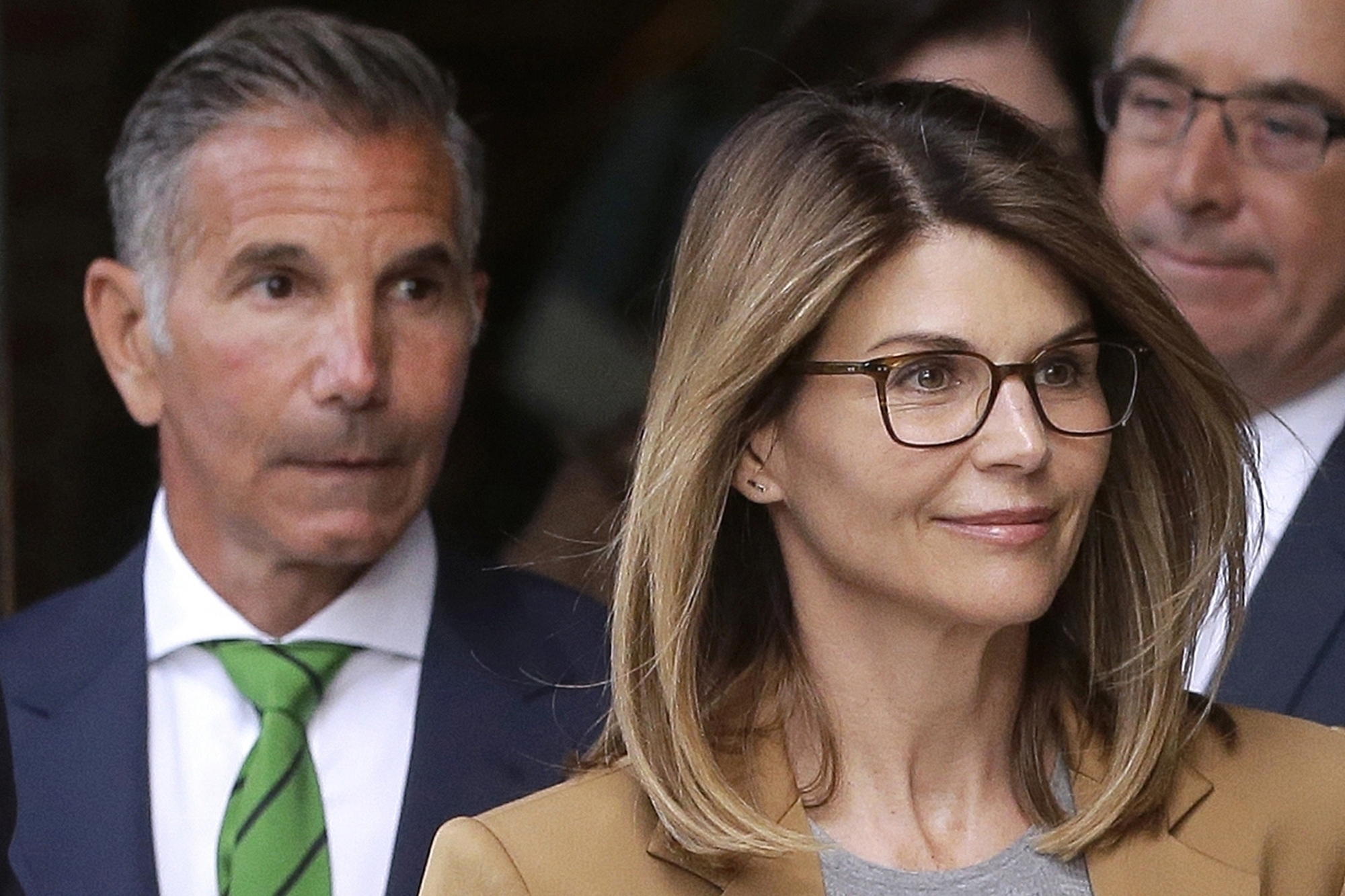 Actress Lori Loughlin, front, and her husband, clothing designer Mossimo Giannulli, left, depart federal court in Boston after a hearing in a nationwide college admissions bribery scandal on April 3, 2019. (AP Photo/Steven Senne, File)