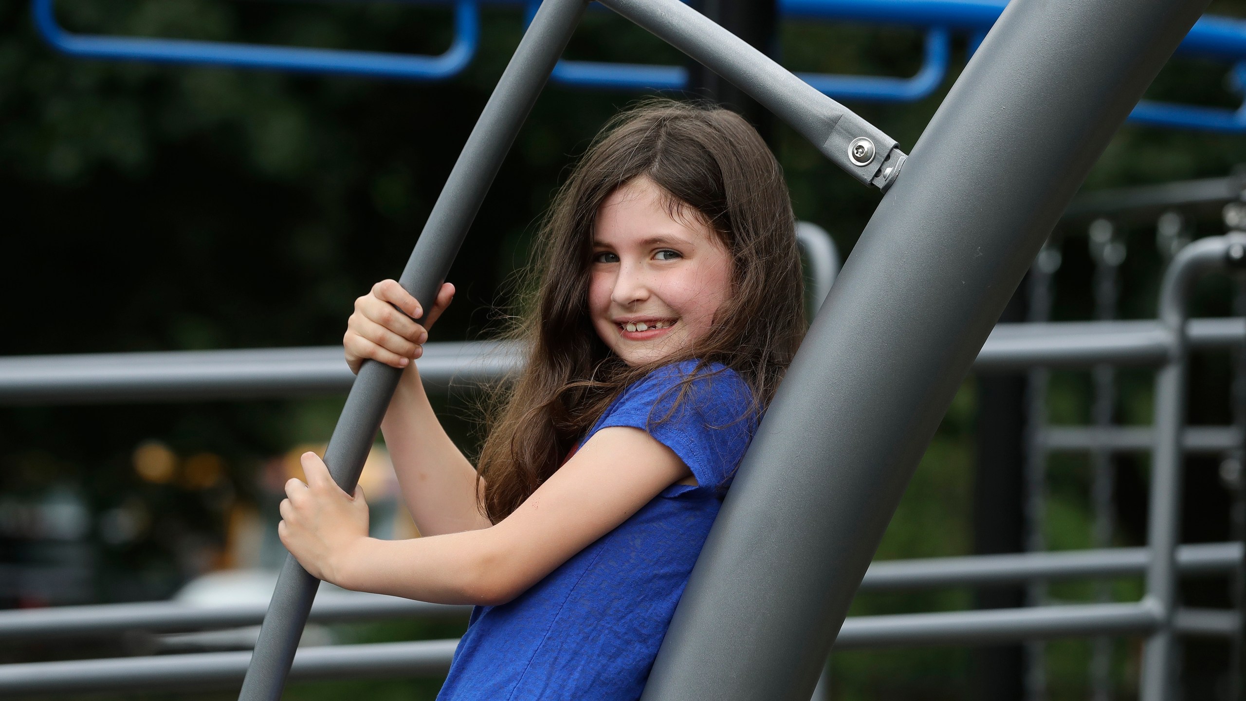 Sophia Garabedian, 6, of Sudbury, Massachusetts, who contracted Eastern Equine Encephalitis in 2019, stands for a photograph on a playground on July 8, 2020, in Sudbury. (AP Photo/Steven Senne)