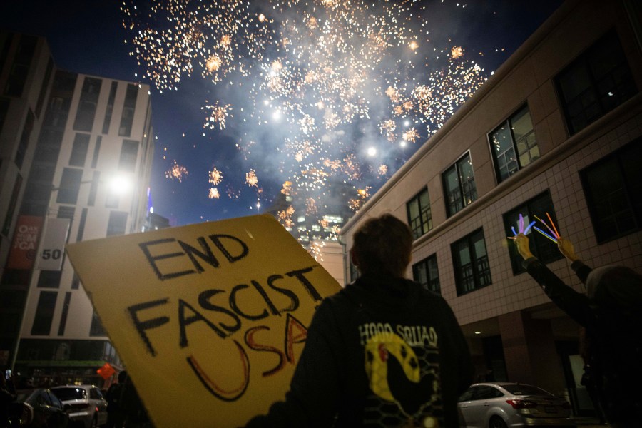 Protesters light fireworks in the middle of downtown Oakland during a protest on Saturday, July 25, 2020, in Oakland, Calif. Protesters in California set fire to a courthouse, damaged a police station and assaulted officers after a peaceful demonstration intensified late Saturday, Oakland police said. (AP Photo/Christian Monterrosa)