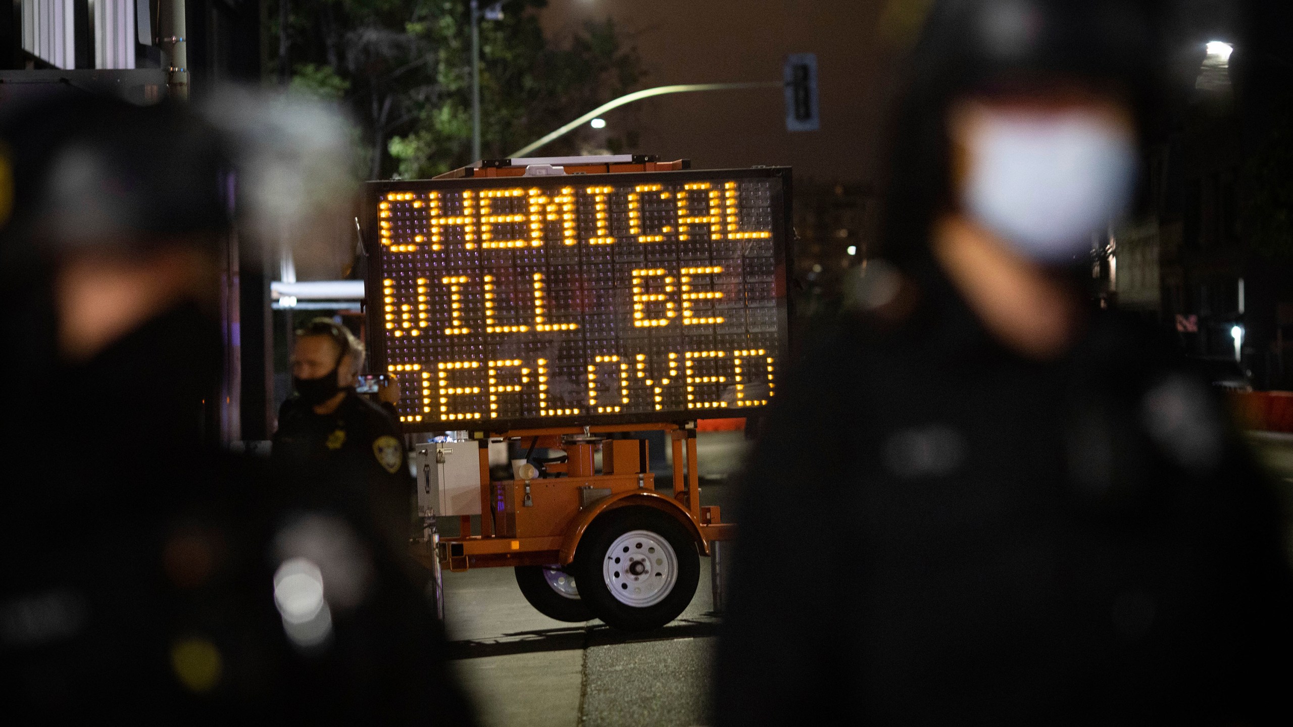 A road sign warns protesters of the use of chemical agents for failure to disperse after a protest was declared unlawful on Saturday, July 25, 2020, in Oakland. (AP Photo/Christian Monterrosa)