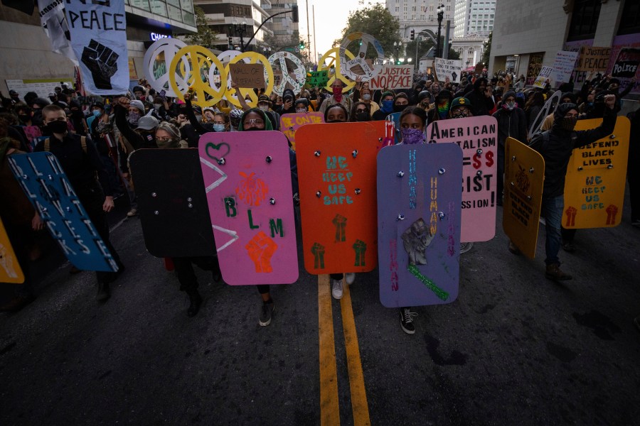 Black Lives Matter protesters march through downtown Oakland on Saturday, July 25, 2020, in Oakland, Calif. Protesters in California set fire to a courthouse, damaged a police station and assaulted officers after a peaceful demonstration intensified late Saturday, Oakland police said. (AP Photo/ Christian Monterrosa)