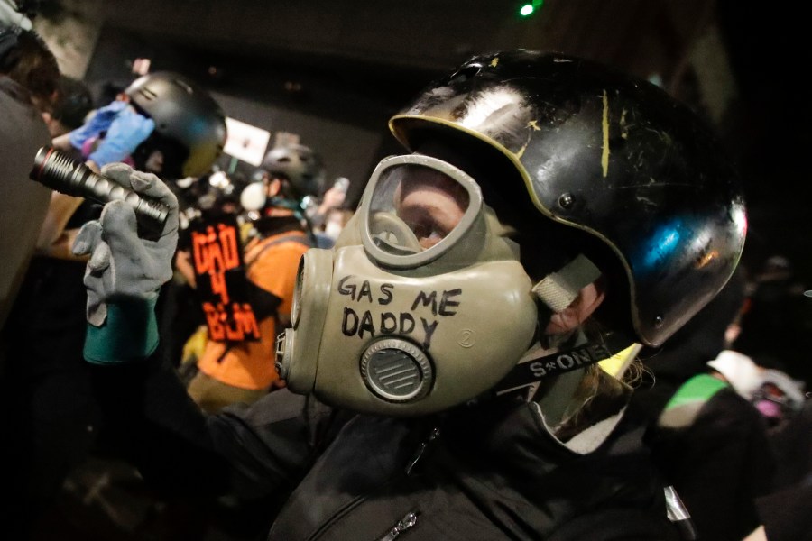 A demonstrator wears a face mask during a Black Lives Matter protest at the Mark O. Hatfield United States Courthouse Saturday, July 25, 2020, in Portland, Ore. (AP Photo/Marcio Jose Sanchez)