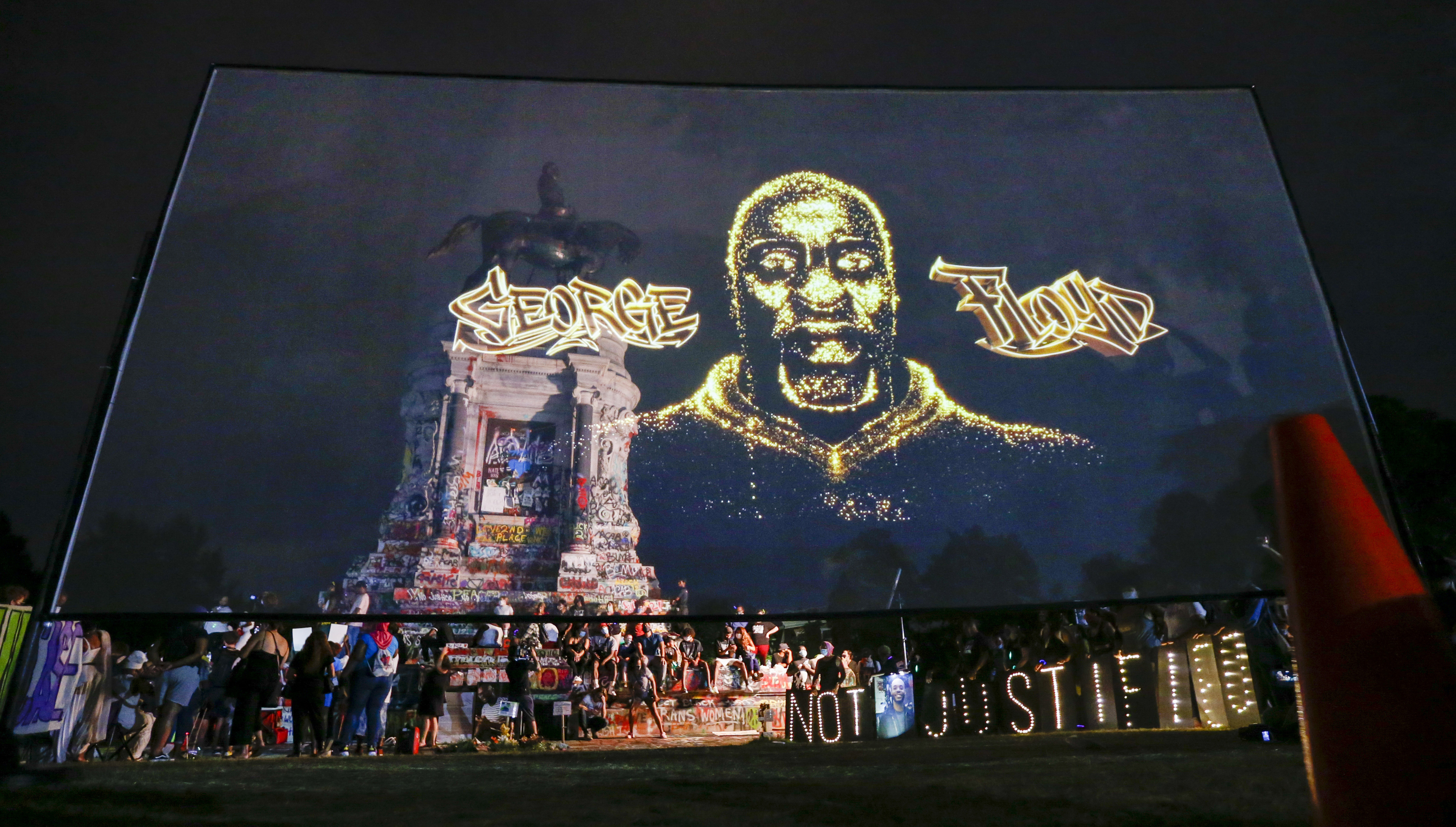 An image of George Floyd is projected on a screen in front of a statue of Confederate Gen. Robert E. Lee in Richmond, Virginia, on July 28, 2020. (Steve Helber / Associated Press)