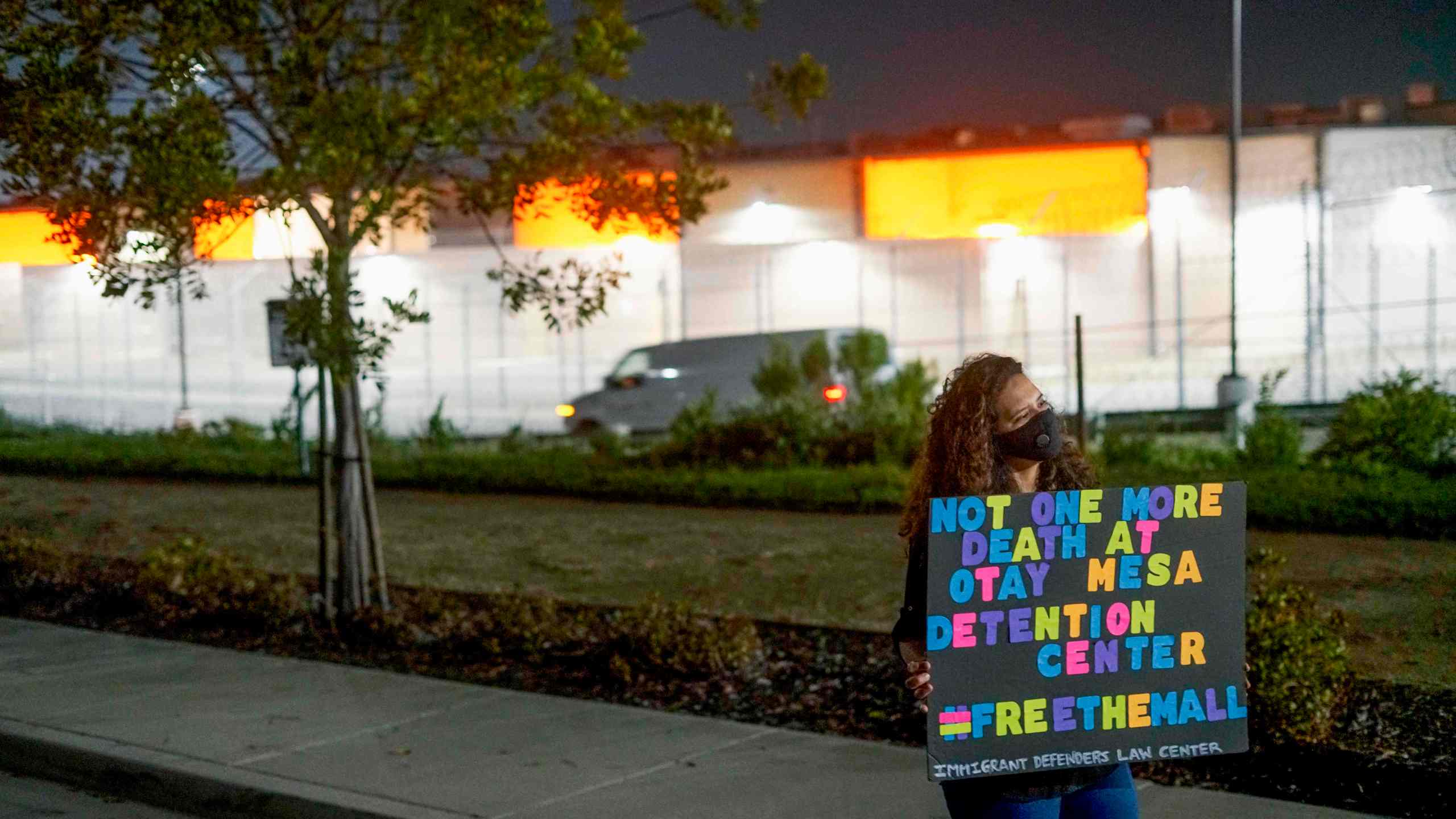 A Protester stands outside the Otay Mesa Detention Center during a "Vigil for Carlos" rally on May 9, 2020. The vigil was held to commemorate Carlos Ernesto Escobar Mejia, the first immigrant who died of COVID-19 related symptoms while being held at the detention Center. (SANDY HUFFAKER / AFP via Getty Images)