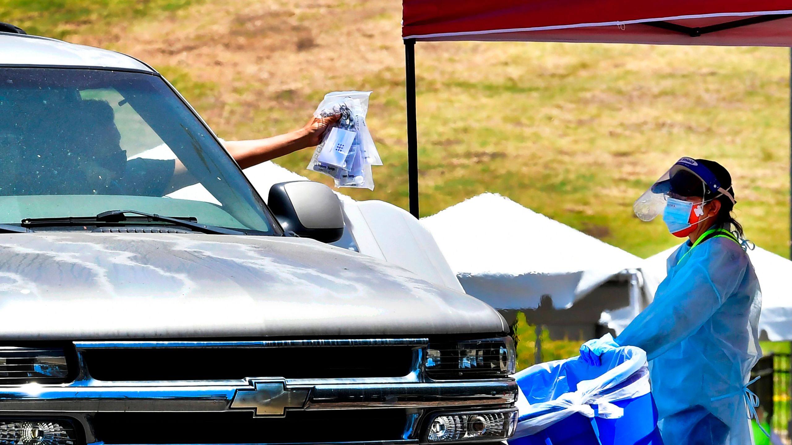 COVID-19 tests are dropped off at a drive-thru site in Los Angeles on June 30, 2020. (Frederic J. Brown / AFP / Getty Images)