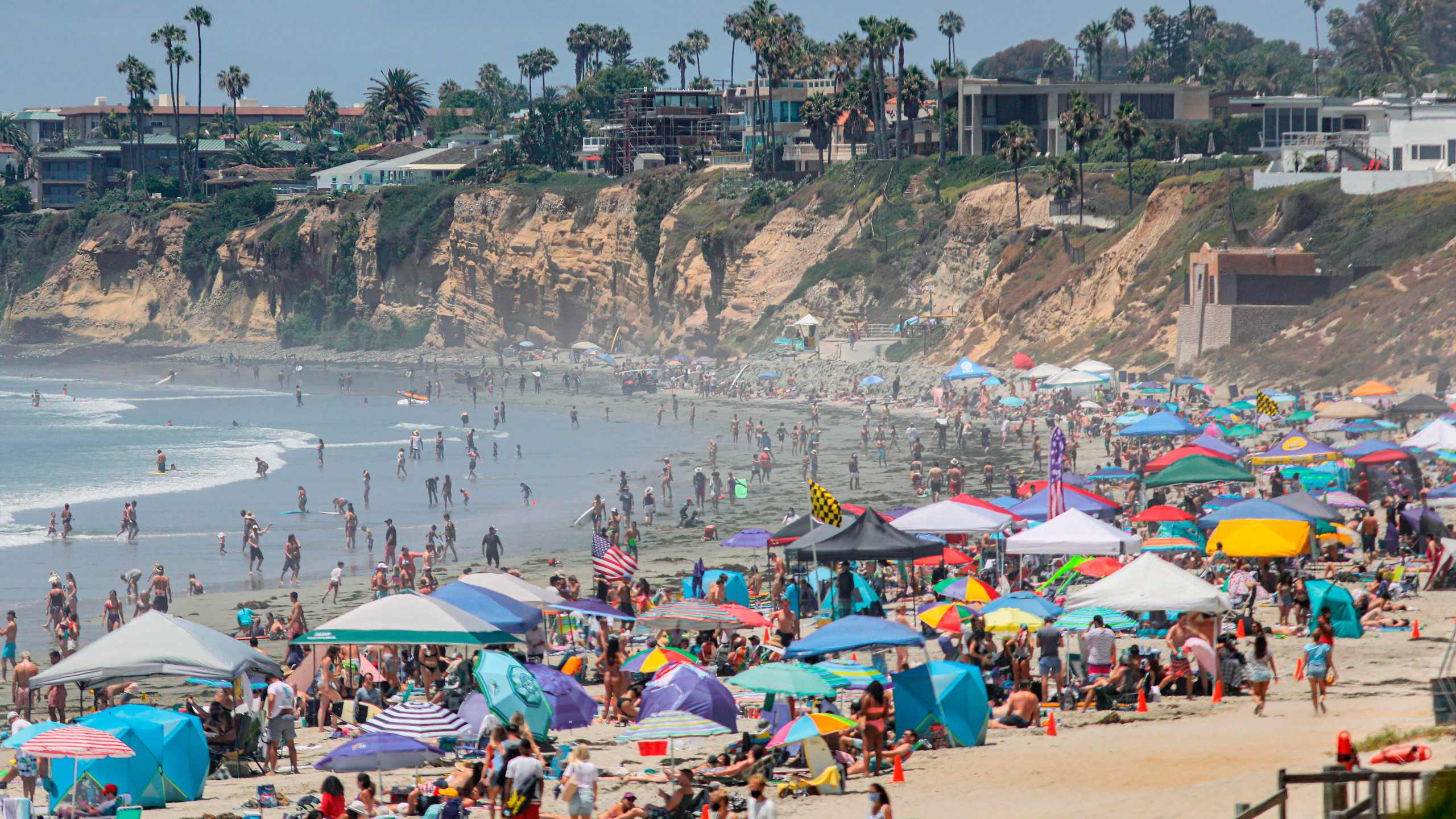 Beachgoers are seen along the shore in the Pacific Beach area of San Diego on July 4, 2020. (SANDY HUFFAKER/AFP via Getty Images)