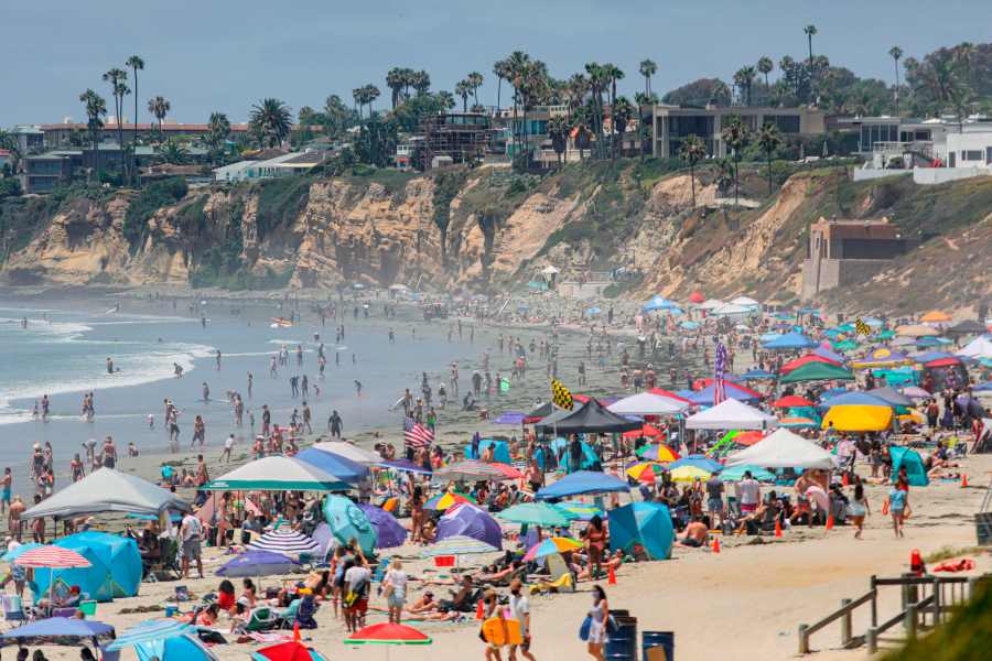 Beachgoers are seen along the shore in the Pacific Beach area of San Diego on July 4, 2020. (SANDY HUFFAKER/AFP via Getty Images)