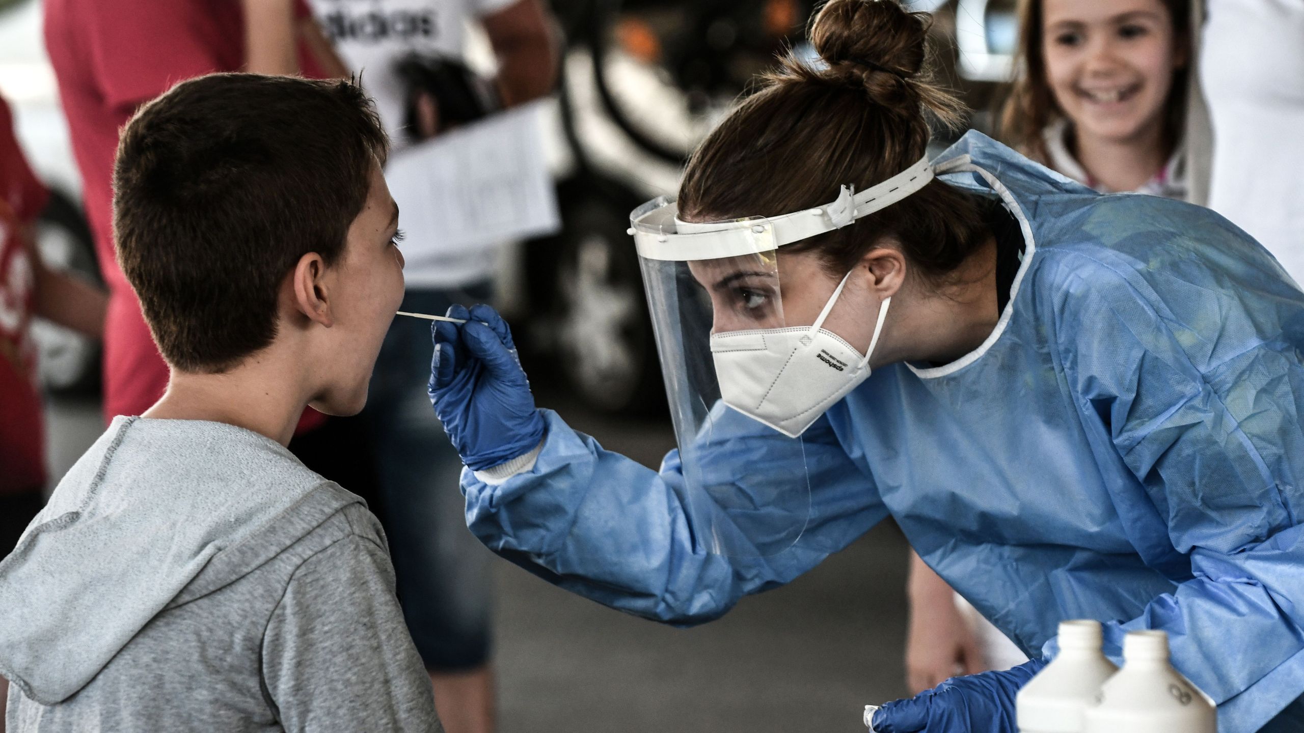 A public health worker collects a swab sample from a boy to test for the COVID-19 at the Greek-Bulgarian border crossing in Promachonas on July 10, 2020. (SAKIS MITROLIDIS/AFP via Getty Images)