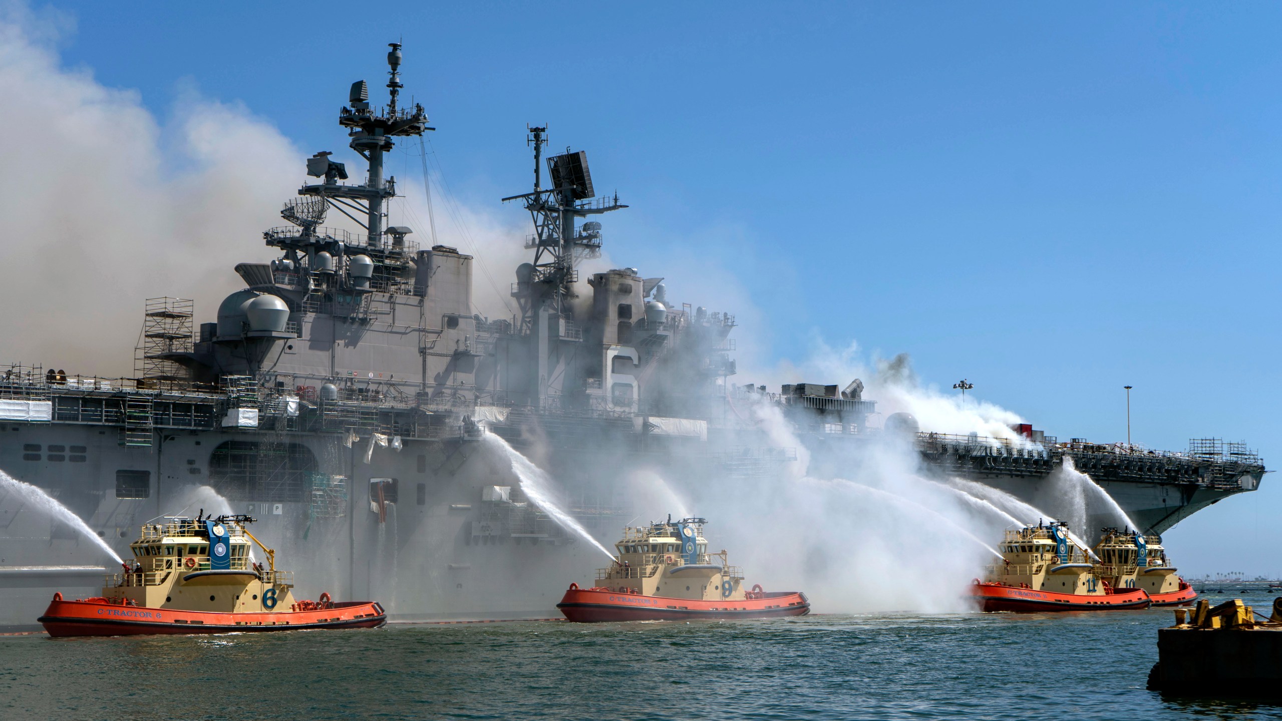 In this U.S. Navy released handout, sailors and federal firefighters combat a fire onboard USS Bonhomme Richard at Naval Base San Diego on July 12, 2020. (U.S. Navy photo by Mass Communication Specialist 3rd Class Christina Ross)