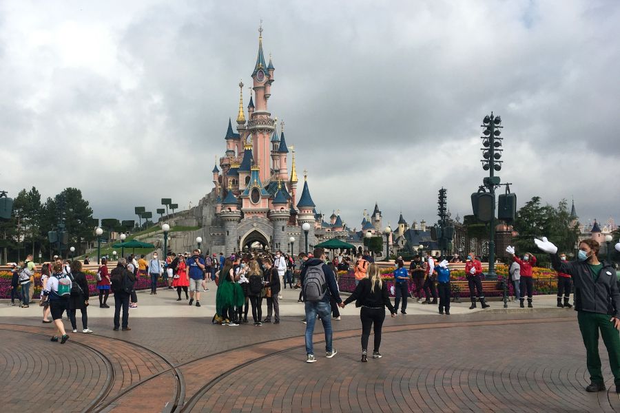 Visitors and staff wearing protective face masks walk down the Main Street of Disneyland Paris on July 15, 2020.(AURELIA MOUSSLY/AFP via Getty Images)