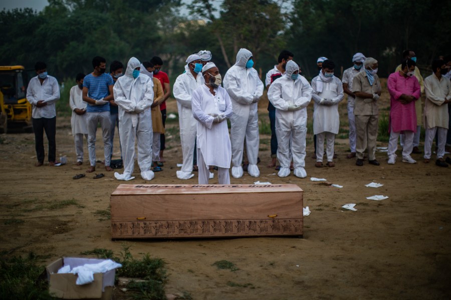 Relatives offer funeral prayers next to the coffin containing the body of a 35-year-old man who died from COVID-19 on July 17, 2020 in New Delhi, India. (Yawar Nazir/Getty Images)