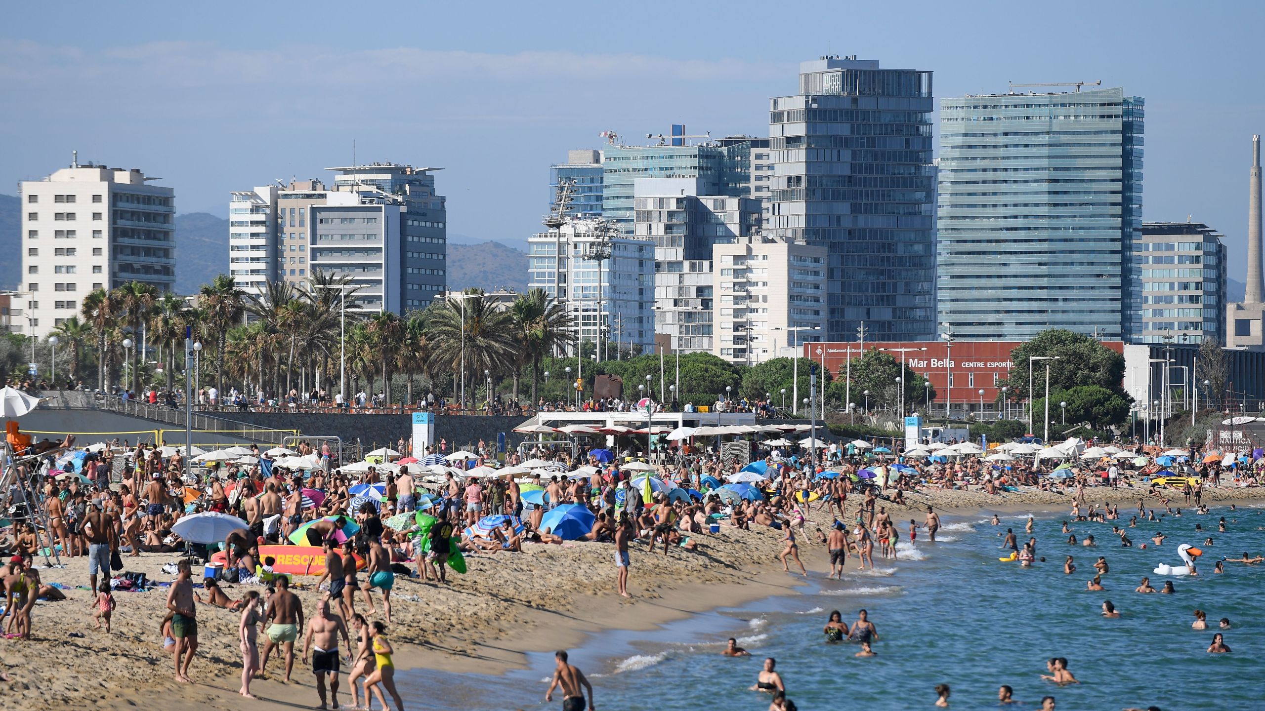 People swim and sunbathe at the Bogatell beach in Barcelona, one of the several sands of the city that have been closed on July 19, 2020, due to reaching the allowed capacity. (Josep LAGO / AFP via Getty Images)