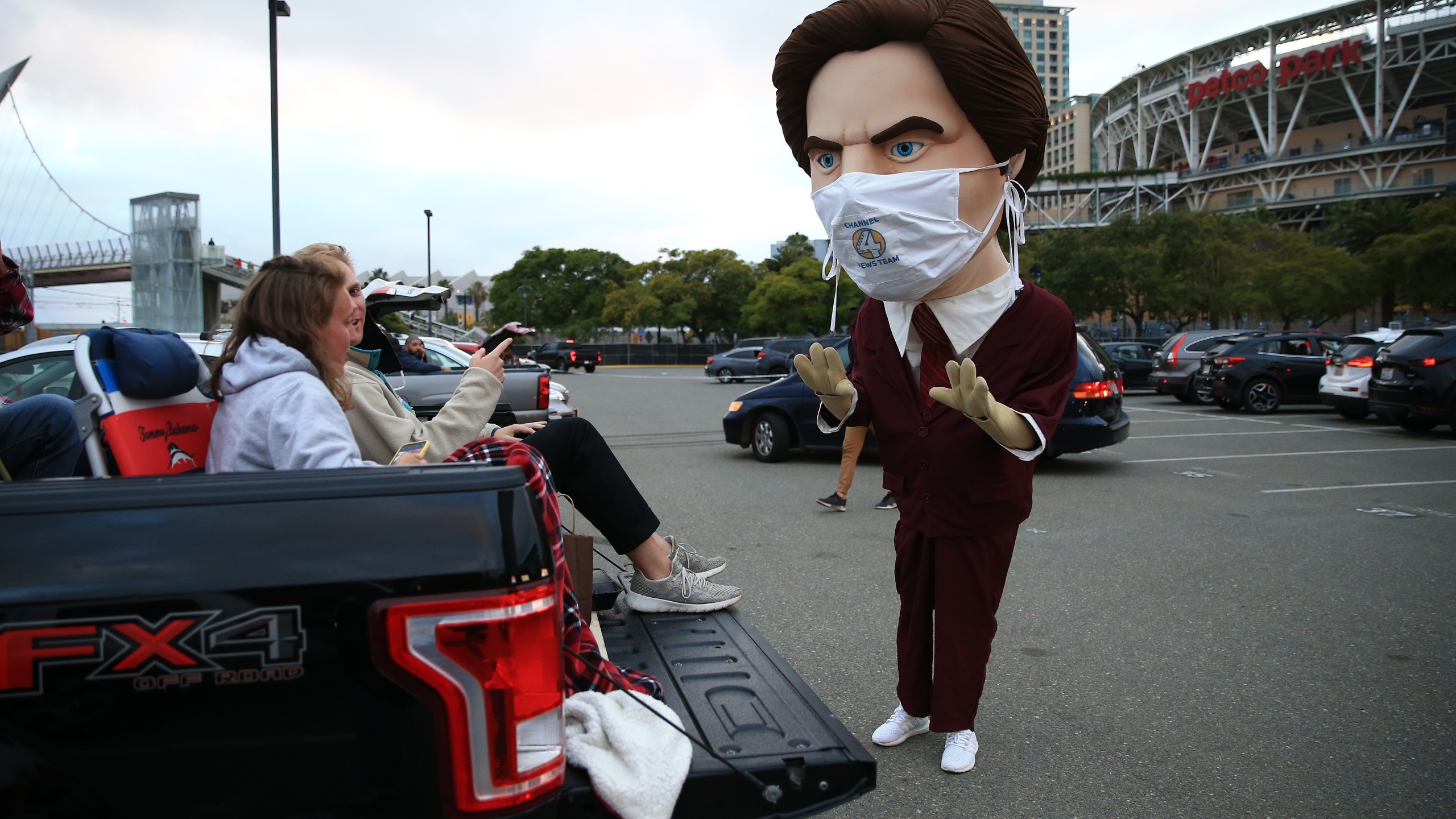 Fans of the San Diego Padres prepare to watch the movie Anchorman as they speak to a mascot of character Ron Burgundy outside of Petco Park at a drive-in movie on June 6, 2020, in San Diego. (Sean M. Haffey/Getty Images)