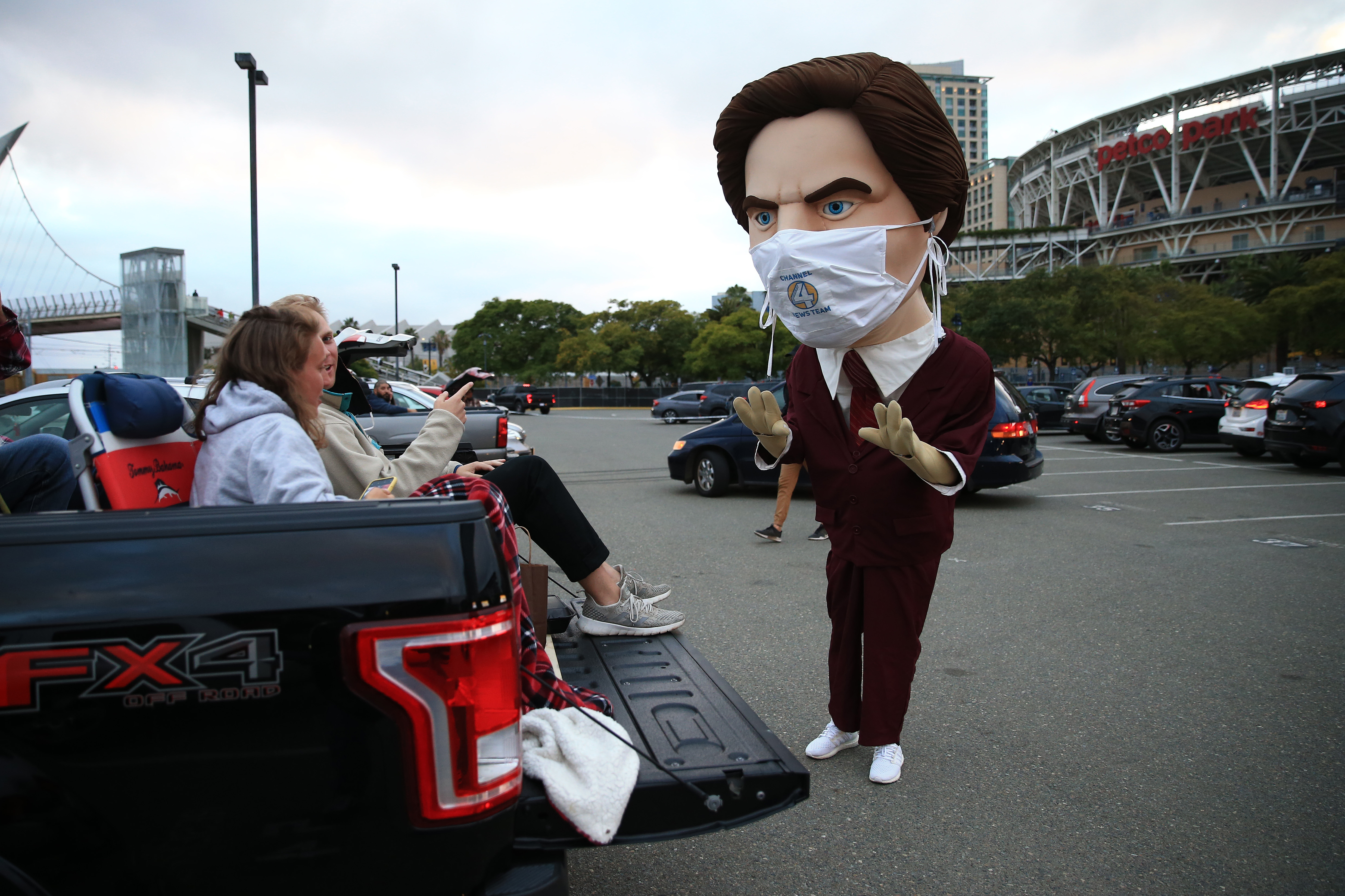 Fans of the San Diego Padres prepare to watch the movie Anchorman as they speak to a mascot of character Ron Burgundy outside of Petco Park at a drive-in movie on June 6, 2020, in San Diego. (Sean M. Haffey/Getty Images)