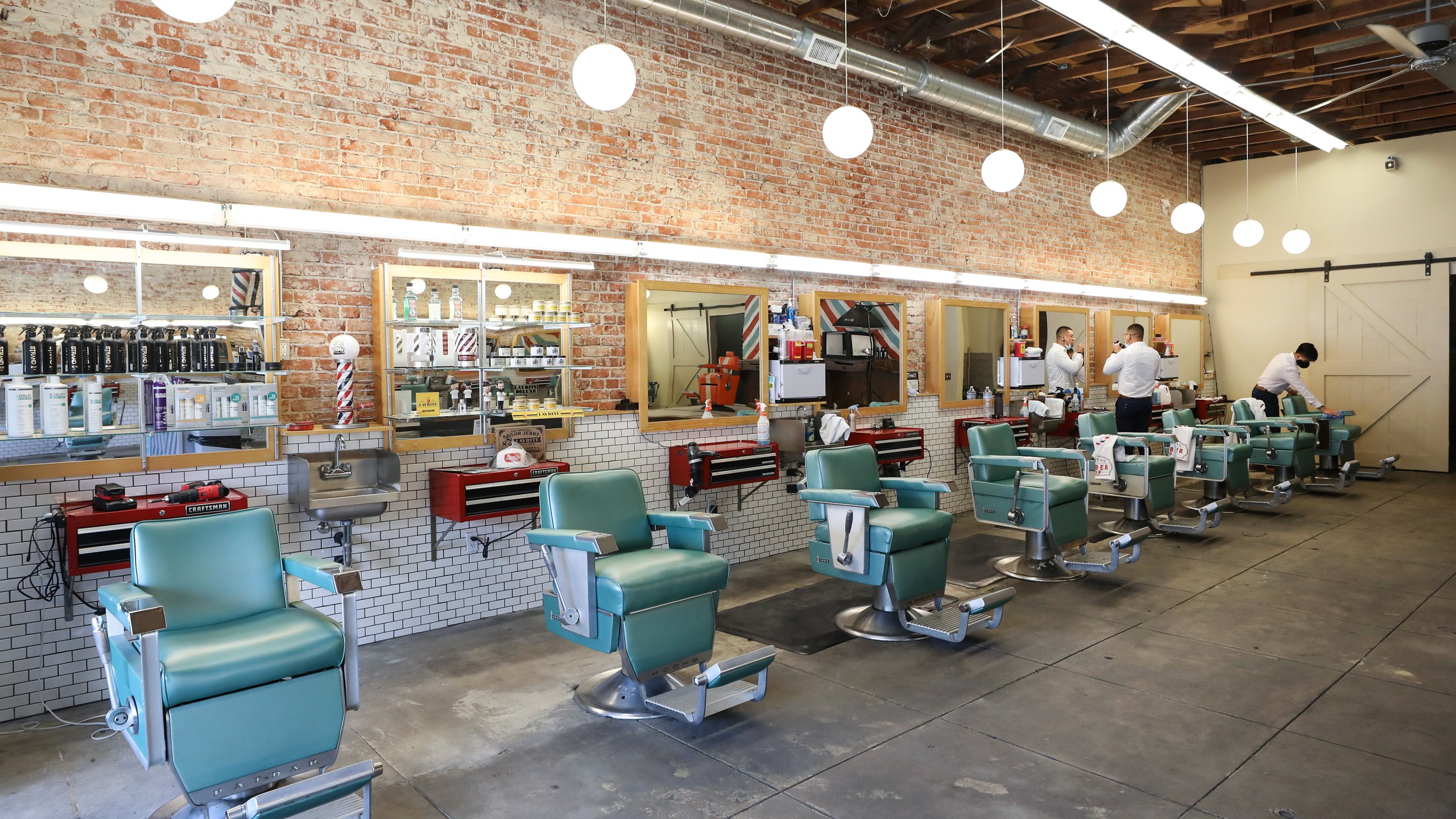 Workers gather in a barbershop as it prepares to close after new closure were announced by Gov. Gavin Newsom on July 14, 2020, in Los Angeles. (Mario Tama/Getty Images)