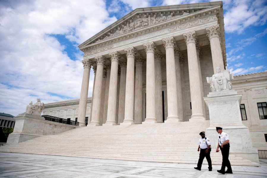 Security officers, one wearing a mask, walk in front of the Supreme Court, Thursday, May 14, 2020, in Washington. (AP Photo/Andrew Harnik)