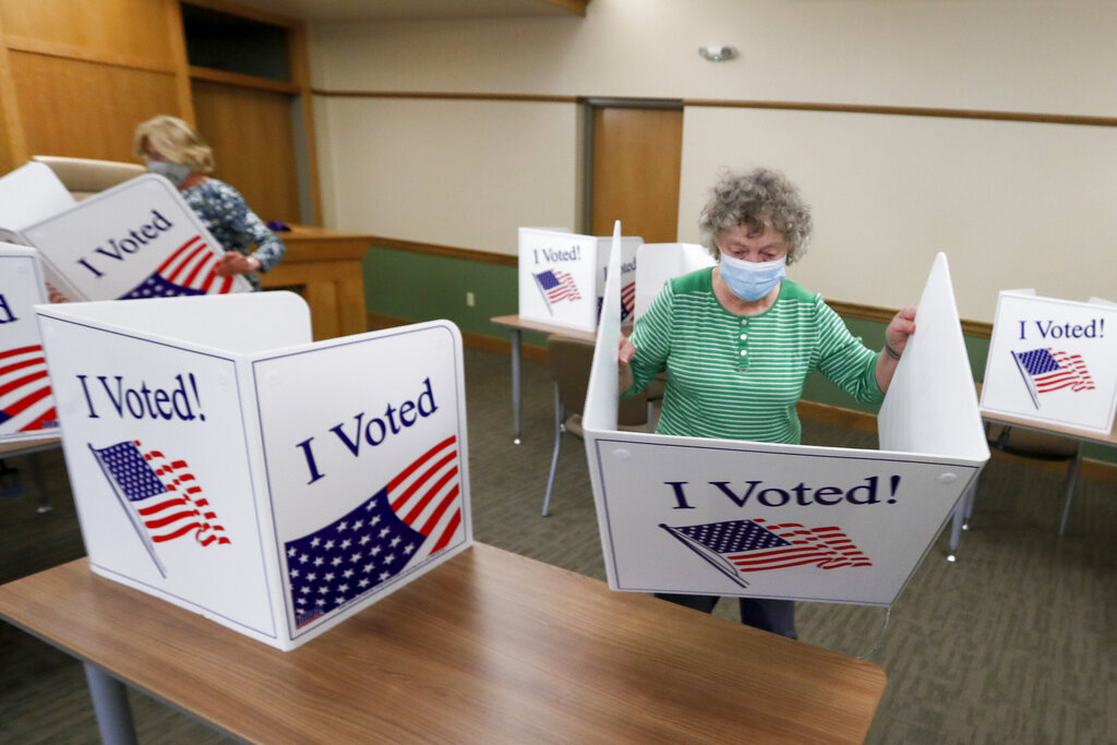 Marty Goetz, right, and Diane White, prepare the voting screens as they start to set up a polling place Monday, June 1, 2020, for the voting for Tuesday's Pennsylvania primary in Jackson Township near Zelienople, Pa. (AP Photo/Keith Srakocic)