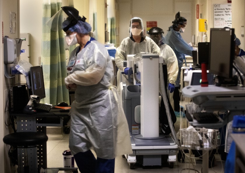 Medical staffers work inside a COVID-19 isolation area at Los Angeles County-USC Medical Center. Medical teams from the Air Force arrived at the hospital, as well as Harbor-UCLA Medical Center, on Friday to offer support in critical care units.(Mel Melcon / Los Angeles Times)