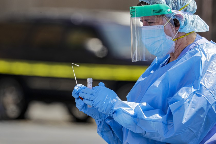 A healthcare worker collects a nasal swab for a coronavirus test in San Bernardino County in April 2020. (Irfan Khan / Los Angeles Times)