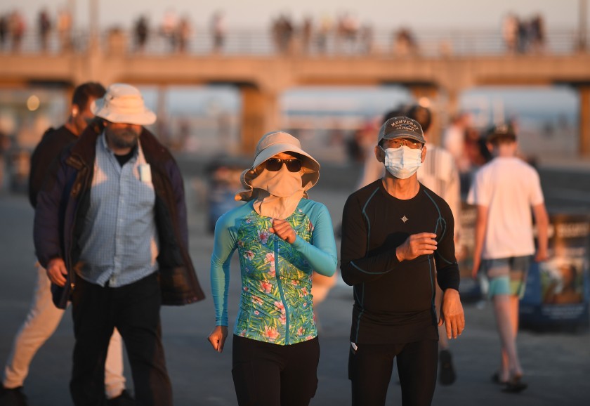 People walk along the strand in Huntington Beach in this undated photo. (Wally Skalij / Los Angeles Times)