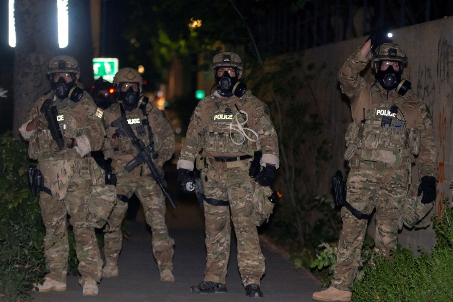 Federal law enforcement officers, deployed under the Trump administration's new executive order to protect federal monuments and buildings, face off with protesters against racial inequality in Portland, Oregon, U.S. July 17, 2020. Picture taken July 17, 2020. (REUTERS/Nathan Howard